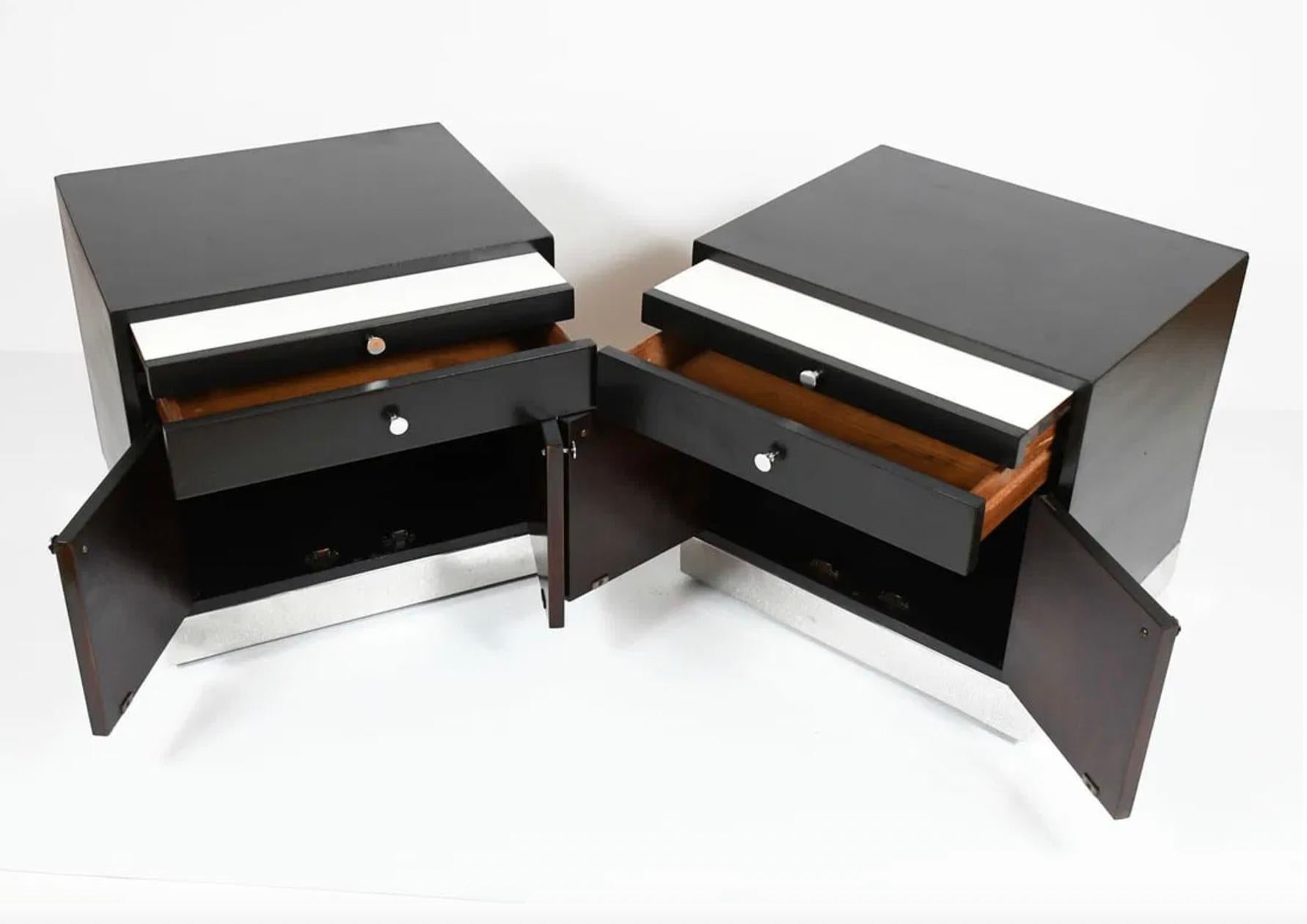 Pair of Black Lacquer nightstands having a pull-out shelf over a single drawer above (2) lower cabinet doors. Chrome wrapped plinth base with chrome pulls. Good vintage condition. Made in USA. Located in Brooklyn NYC.

Sold as a Pair (2)