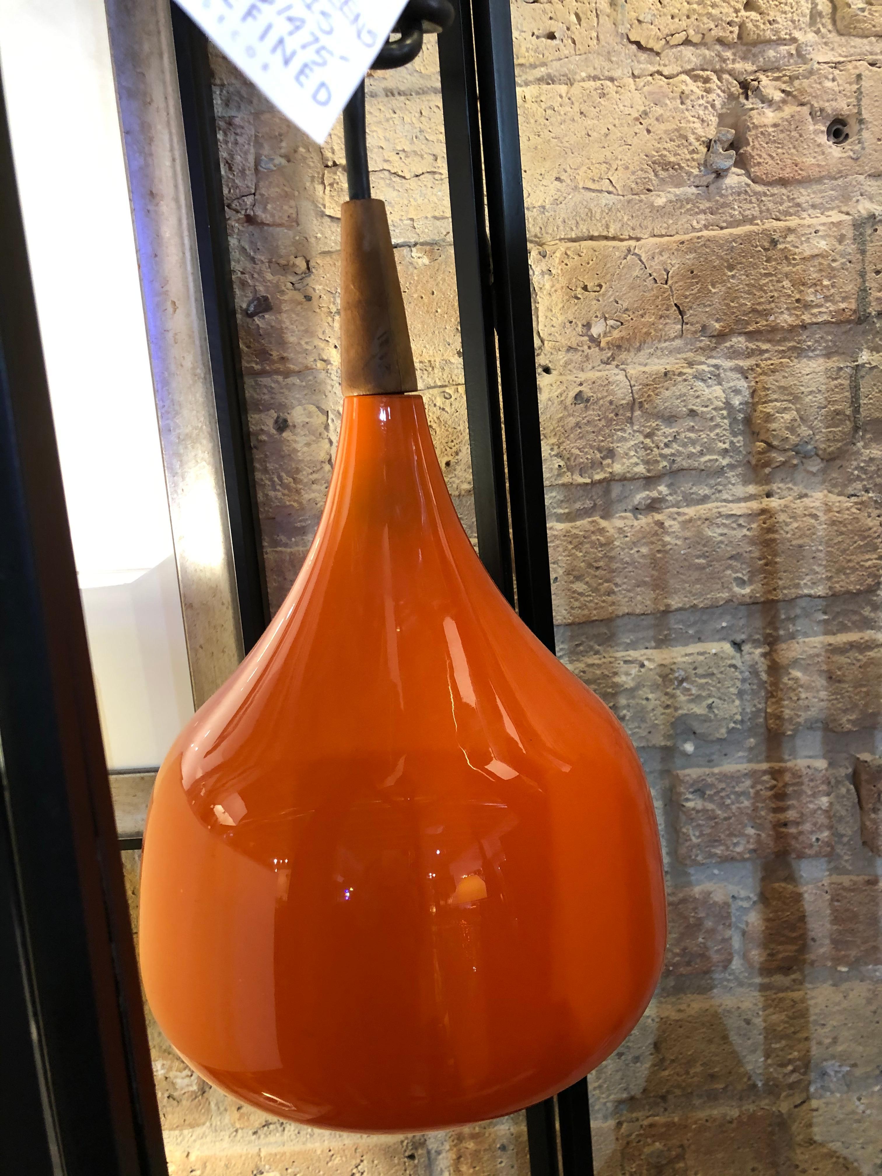  1960s orange cased glass light pendant having walnut detail by Holmegaard of Denmark. Only one available.