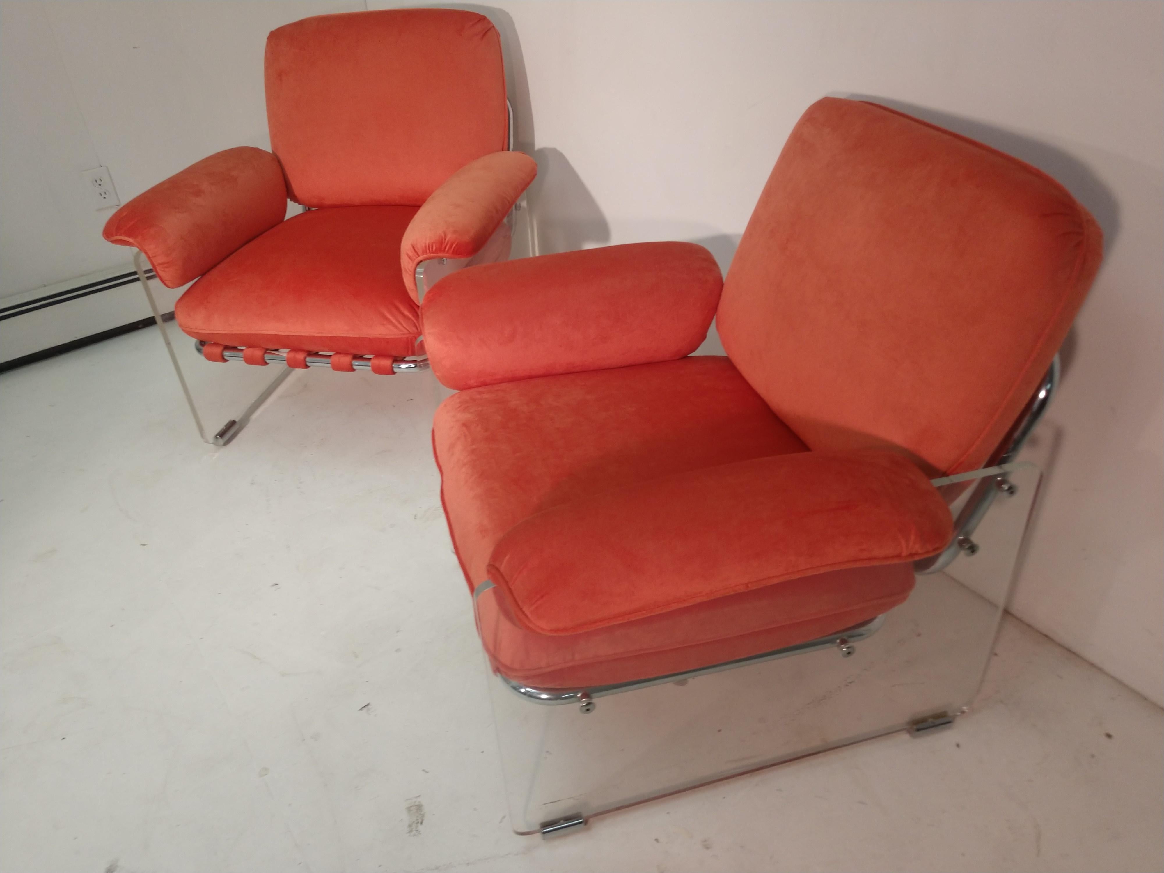 Fabulous pair of Mid-Century Modern Lucite and chrome lounge chairs by Pace. Totally restored in a orange ultra suede. All new foam, material and straps. Thick slabs of Lucite with chrome feet and hardware. The Lucite and chrome in excellent vintage