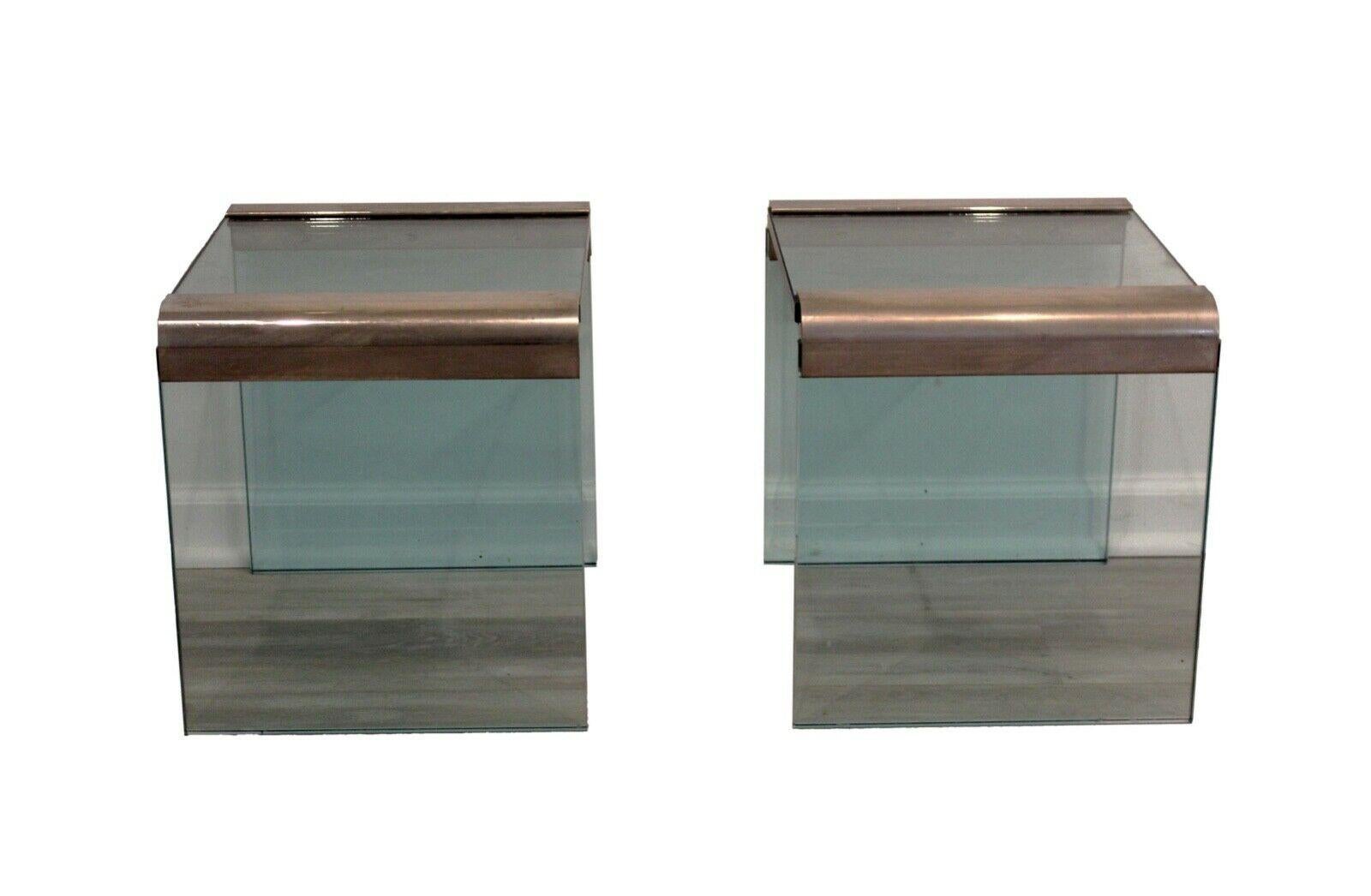 From Le Shoppe Too in Michigan, this pair of postmodern side or end tables made by Pace Manufacturing combines tempered glass with chrome straps easing the waterfall edges. A versatile pair for any modern or postmodern aesthetic. Chrome has some