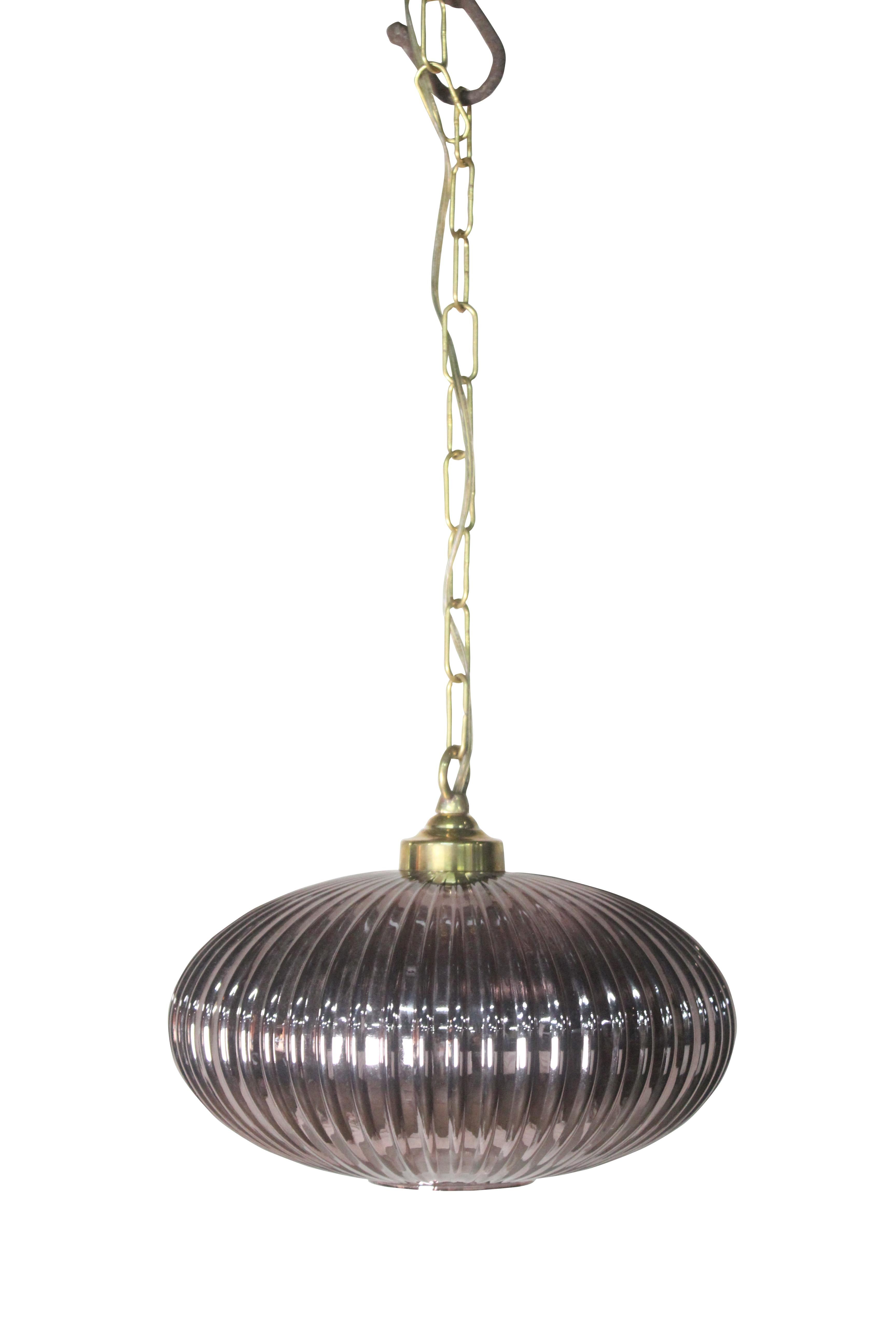A beautiful pair of pale amethyst, ribbed glass pendant lights. Brass light fixture, rewired for American use. 4' of brass chain and ceiling canopy included. Mid-Century Modern, European. This pale amethyst color is very flattering when lit and the
