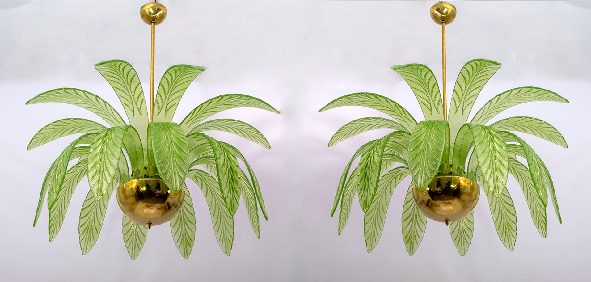 Pair of mouth-blown Murano glass chandeliers, green Murano glass leaves, brass structure, three light bulbs.
The chandelier reproduces the crown of a palm tree.
We supply reducers for E12 USA bulbs.