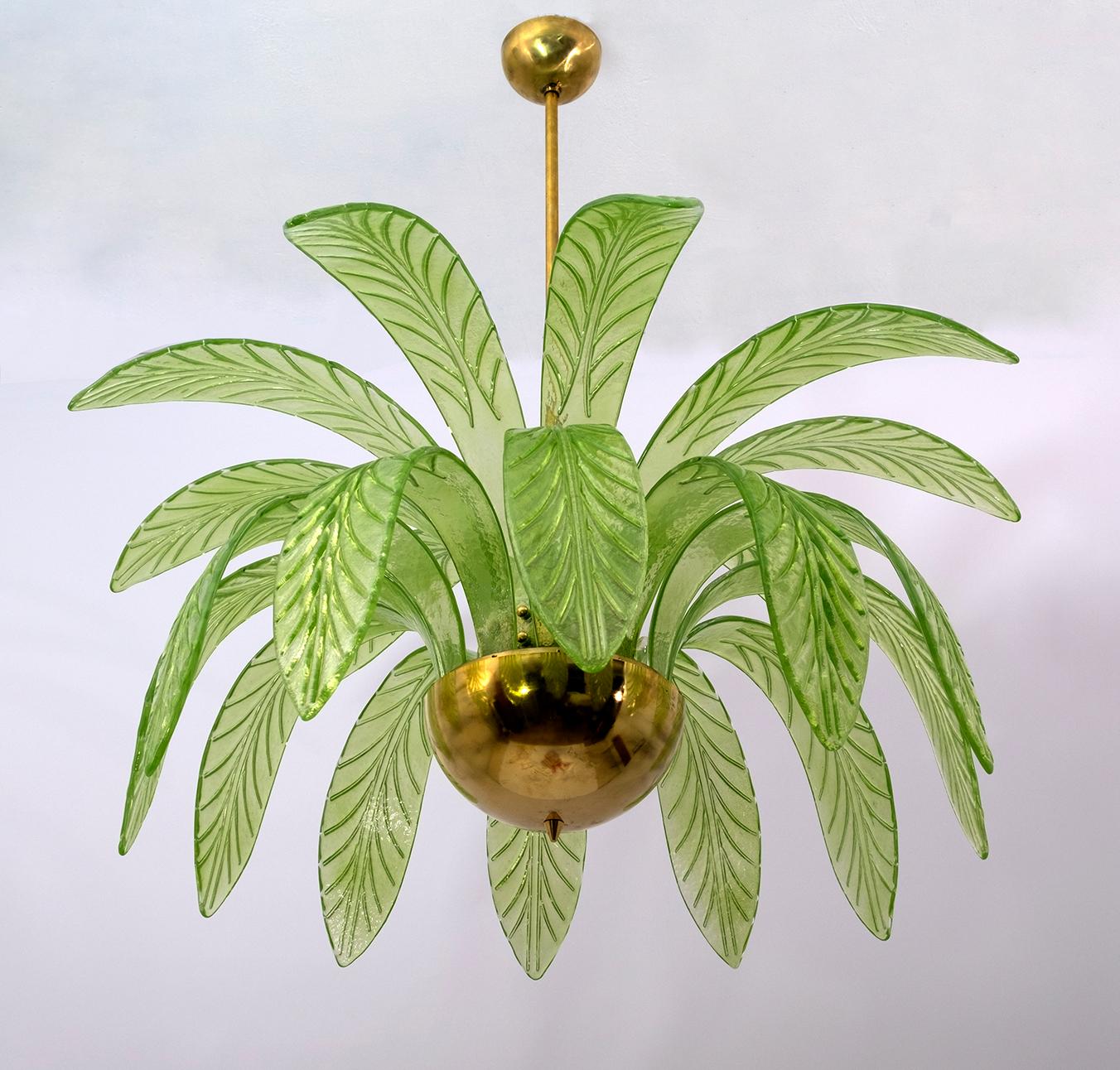 Mouth blown Murano glass chandelier, green Murano glass leaves, brass frame, three light bulbs. The chandelier reproduces the crown of a palm tree. Rewired to European and US standards, equipped with E14 or E12 lamp holder.