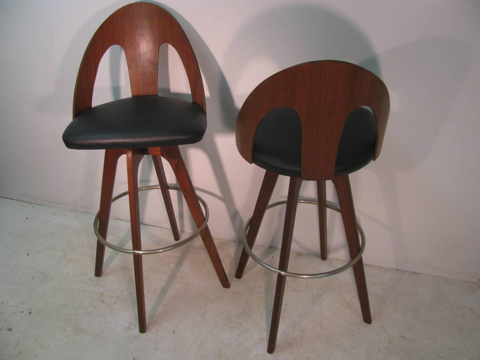 Fabulous pair of walnut pierced spoon back bar stools. Solid walnut back and legs created by Chet Beardsley. Chrome foot ring shows some normal wear.