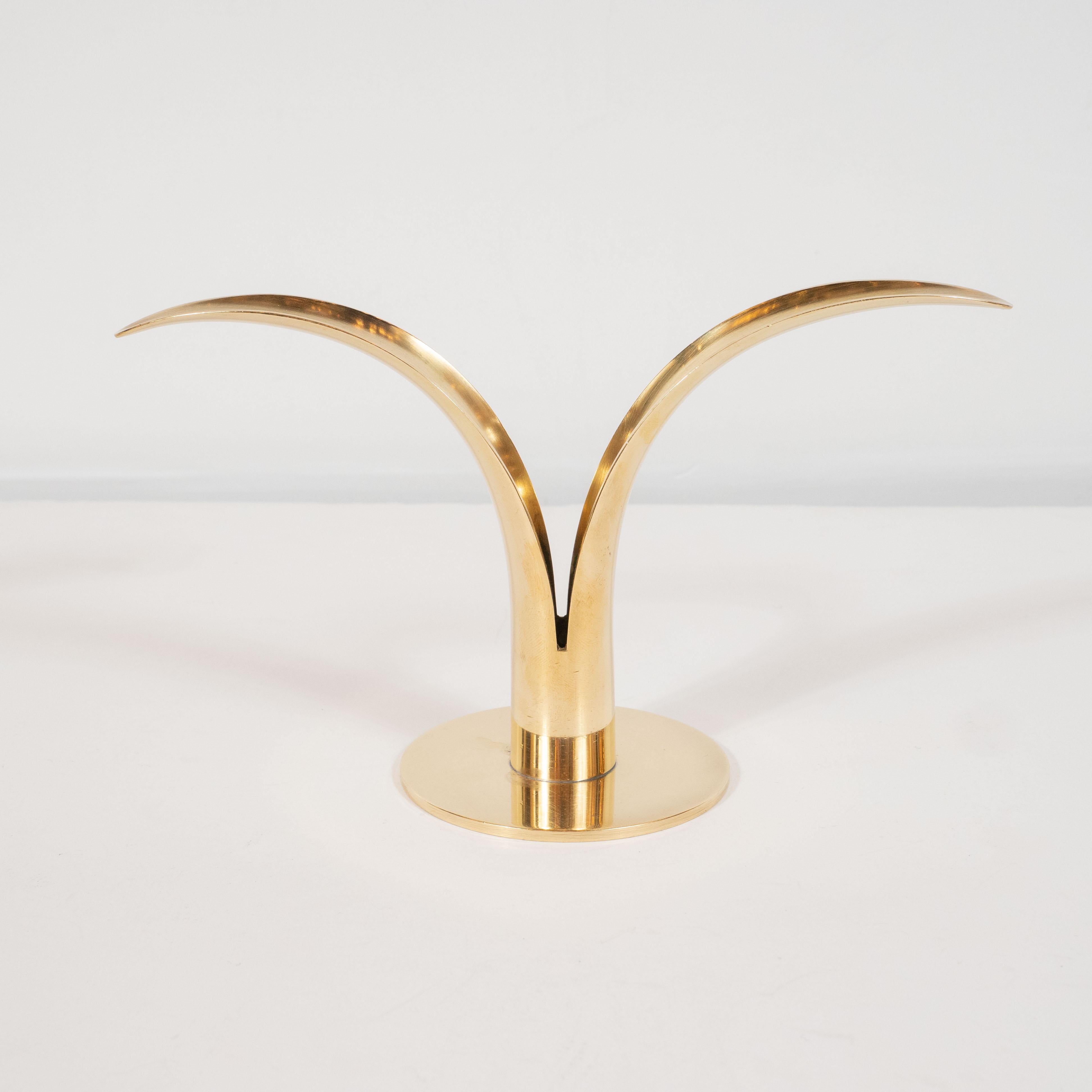 This elegant and graphic pair of candleholders were realized by the esteemed Swedish maker, Konst, circa 1960. The feature curved tapered forms- suggesting two lily petals, rising upwards from a circular base, all realized in lustrous polished