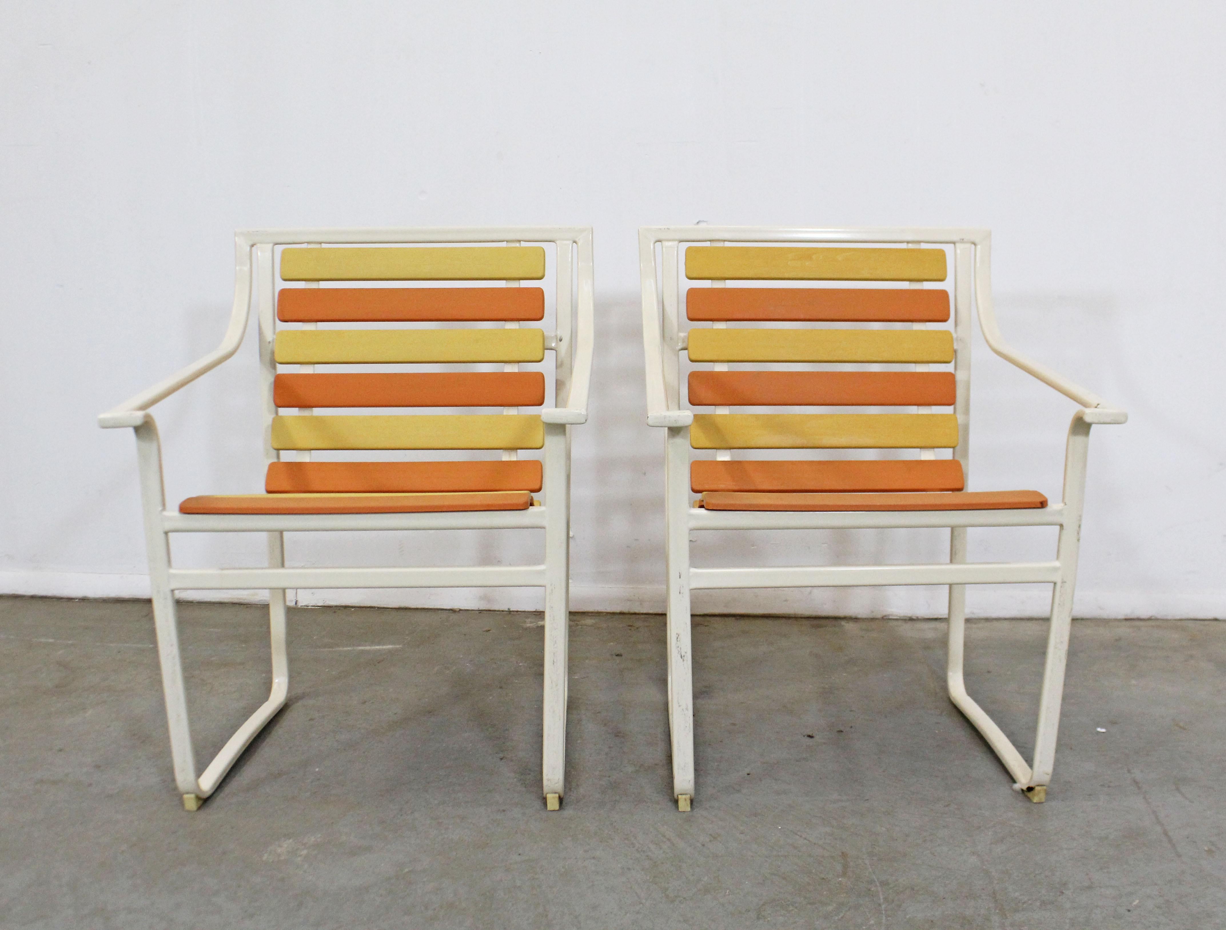 What a find. Offered is a pair of vintage midcentury outdoor arm chairs with flat tubular steel frames and orange/yellow plastic slats. They were made by Samsonite (circa 1960s). In good structurally sound condition, has visible surface wear