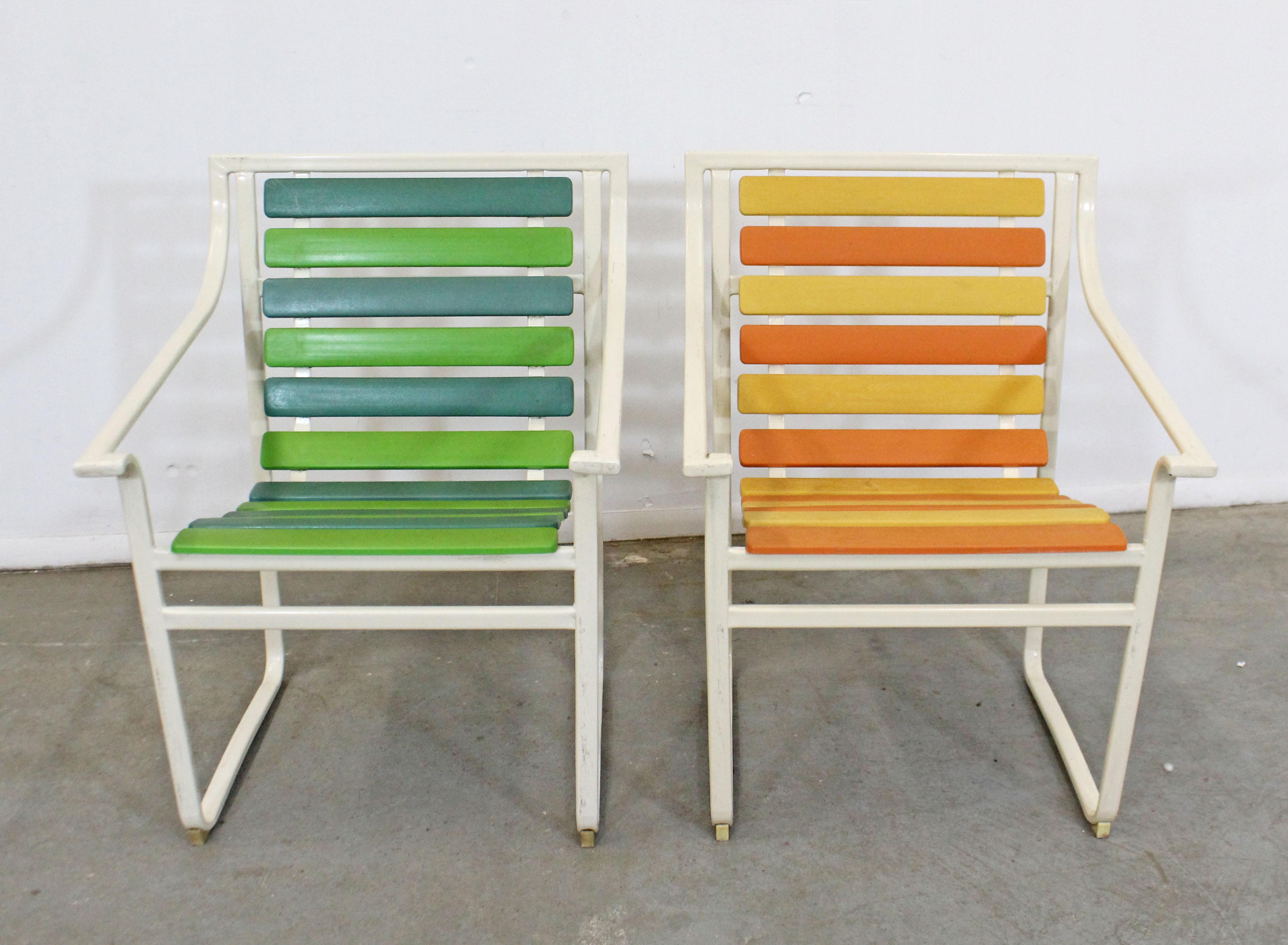 This is a pair of vintage midcentury outdoor armchairs with flat tubular steel frames and multicolored plastic slats. They were made by Samsonite, circa 1960s. In overall decent, structurally sound condition, has visible surface wear including