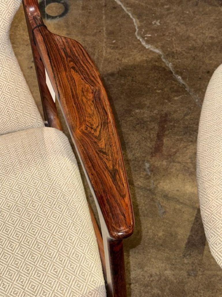 Nice pair of mid-century modern rosewood Danish armchairs from the 1960s. These vintage chairs perfectly capture the retro and mid-century style popular during that time period. Made with quality materials and craftsmanship, these armchairs are a