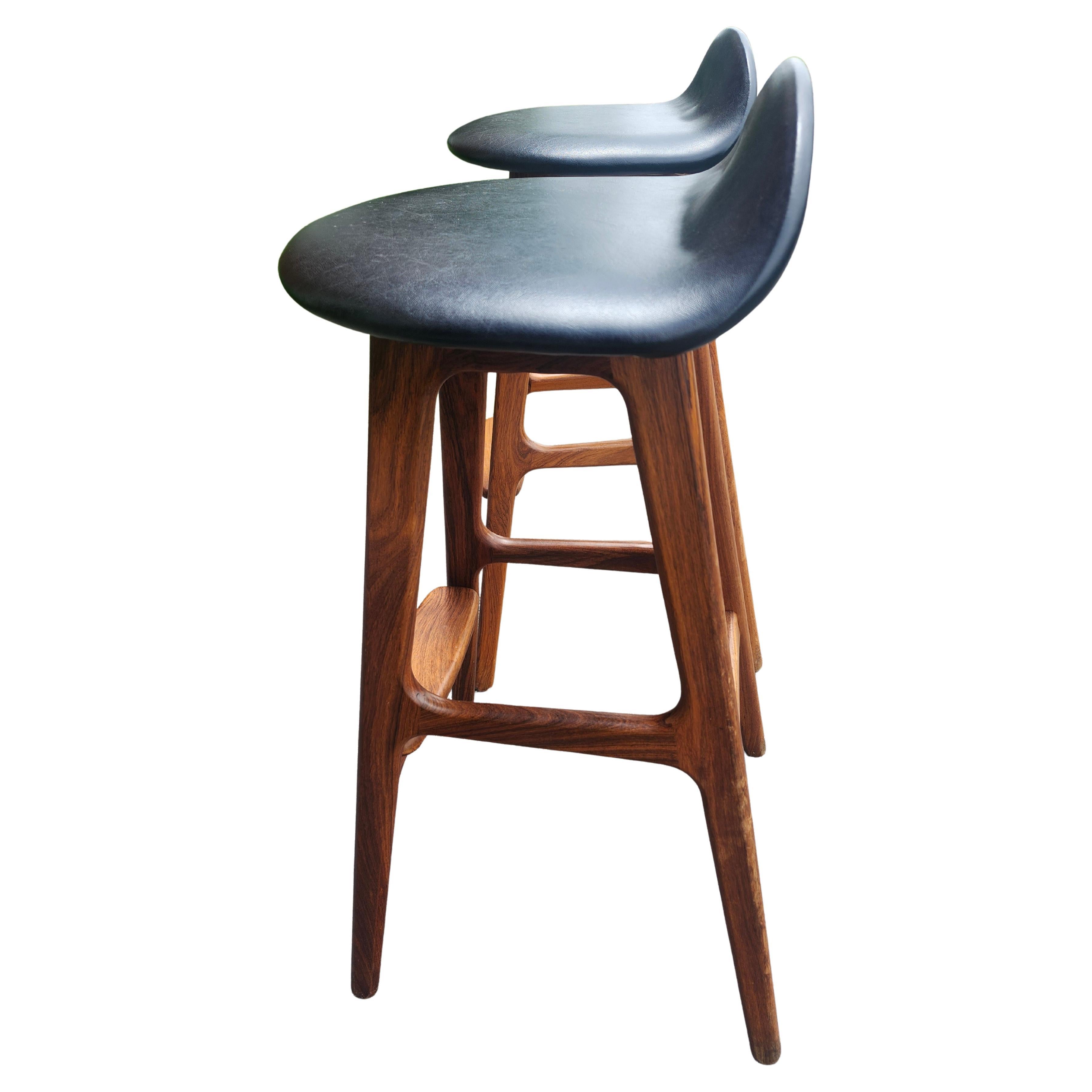 Fantástica pareja de taburetes de bar de palisandro con reposapiés de teca diseñados por Erik Buch a principios de los años sesenta.  Un diseño icónico de un diseñador danés que ha resistido el paso del tiempo. Un par sencillo pero elegante, con una