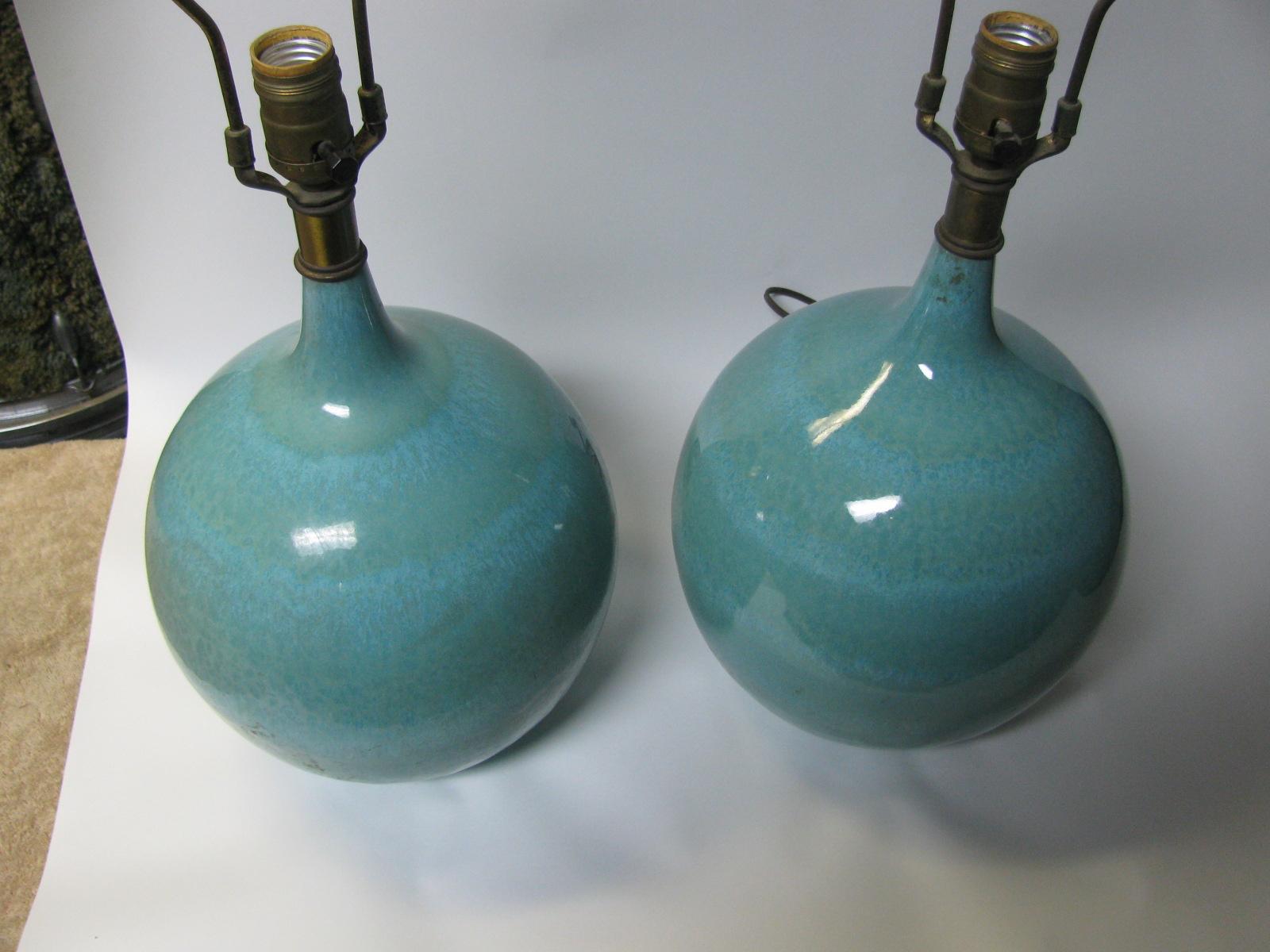 Beautiful pair of turquoise drip glaze round body table lamps. Pictured with white shades which are 23.5 D x 14.5 H. Color changes from turquoise to aqua green with banding, speckles, very serene.