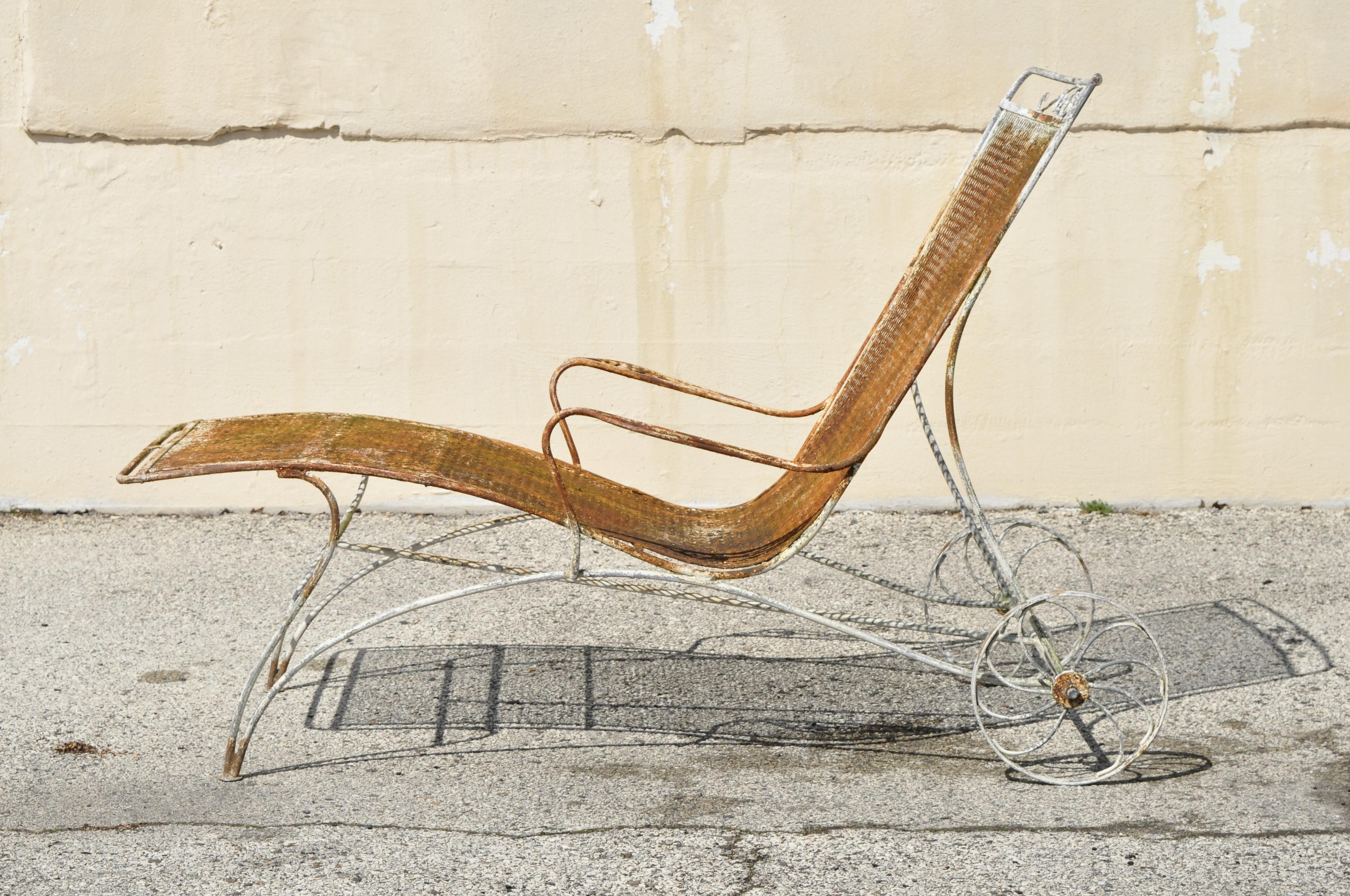 Pair of Mid-Century Modern Russell Woodard wrought iron patio chaise lounge chairs. Item features wide frames, mesh seats, metal wheels, wrought iron, clean modernist lines, sleek sculptural form, circa mid-20th century. Measurements: 43.5