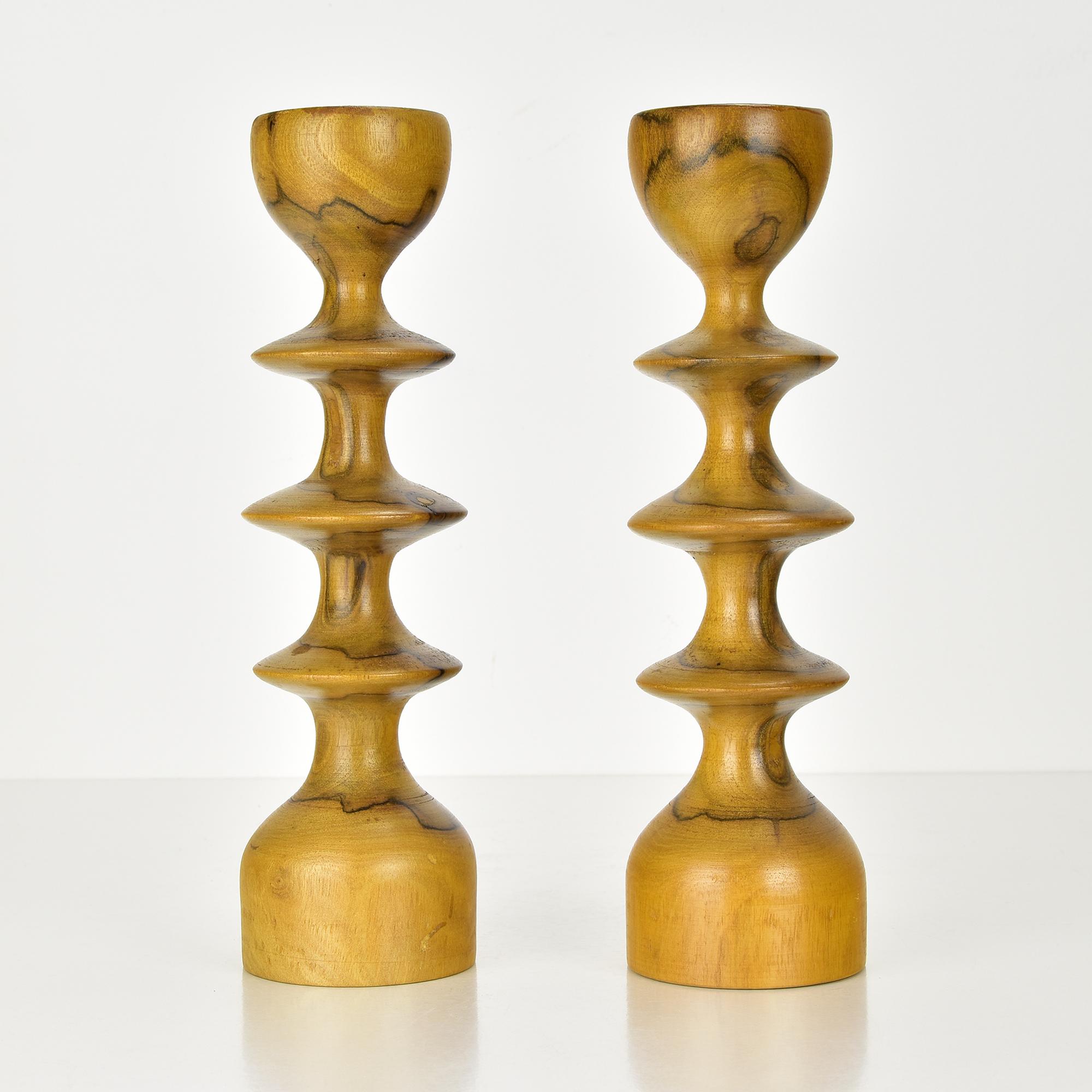 This charming pair of Scandinavian Modern candlesticks exemplifies mid-century craftsmanship with their elegant turned wooden design. Each candlestick features a distinctive silhouette with smooth, sculptural contours that highlight the natural