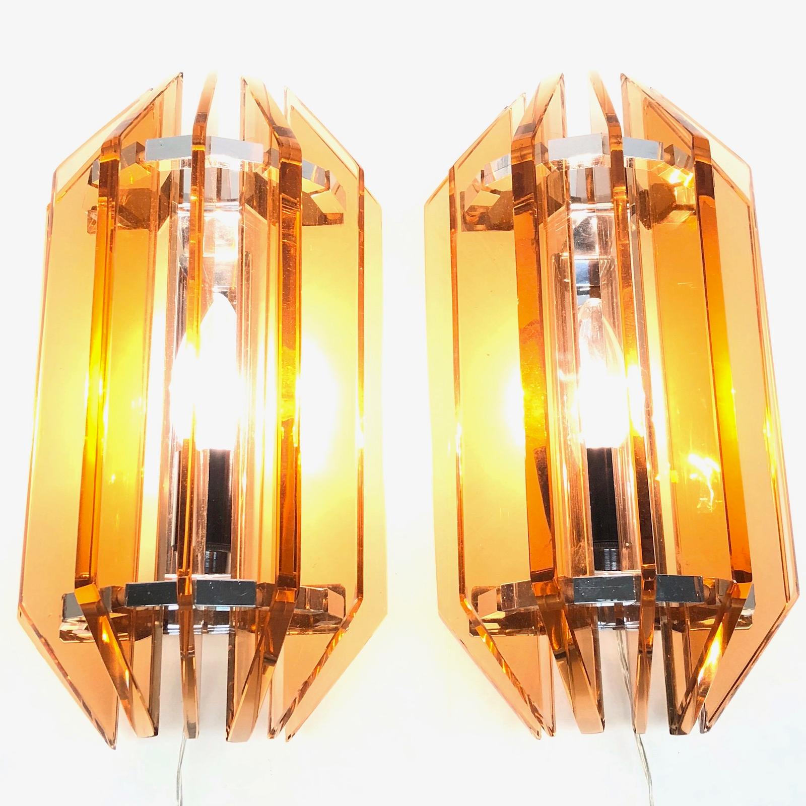A very nice and elegant pair of Italian sconces made by Veca, Italy, in the 1970s. These vintage lights feature handmade, colored glass and the chrome metal frame giving the lights a Minimalist, simple and pleasing contemporary form. Each fixture