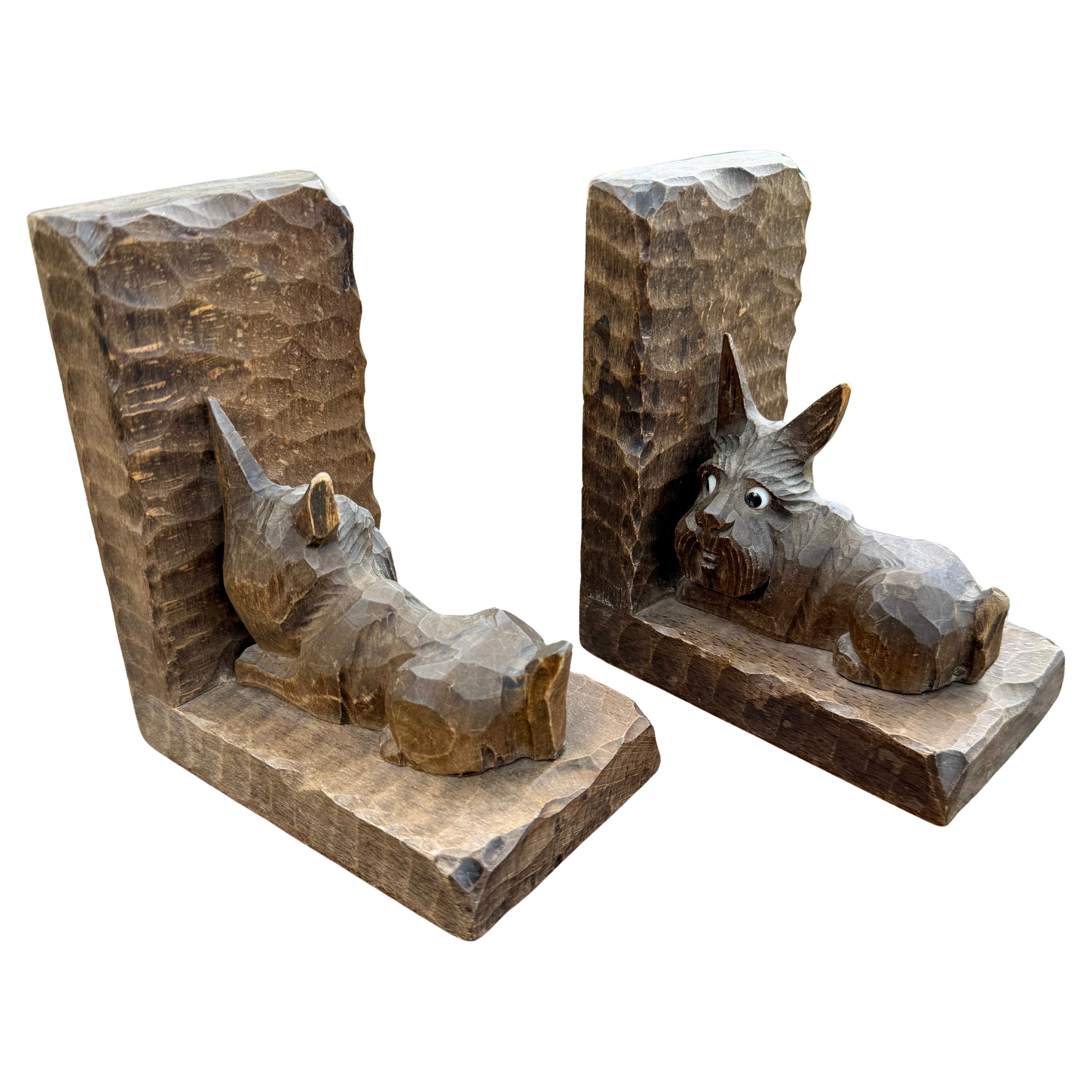 Una coppia di fermalibri intagliati a mano della metà del secolo scorso che rappresentano una coppia di cani Scottish Terrier. Questo set può essere aggiunto a una collezione attuale o appoggiato su uno scaffale di una biblioteca domestica. Questa