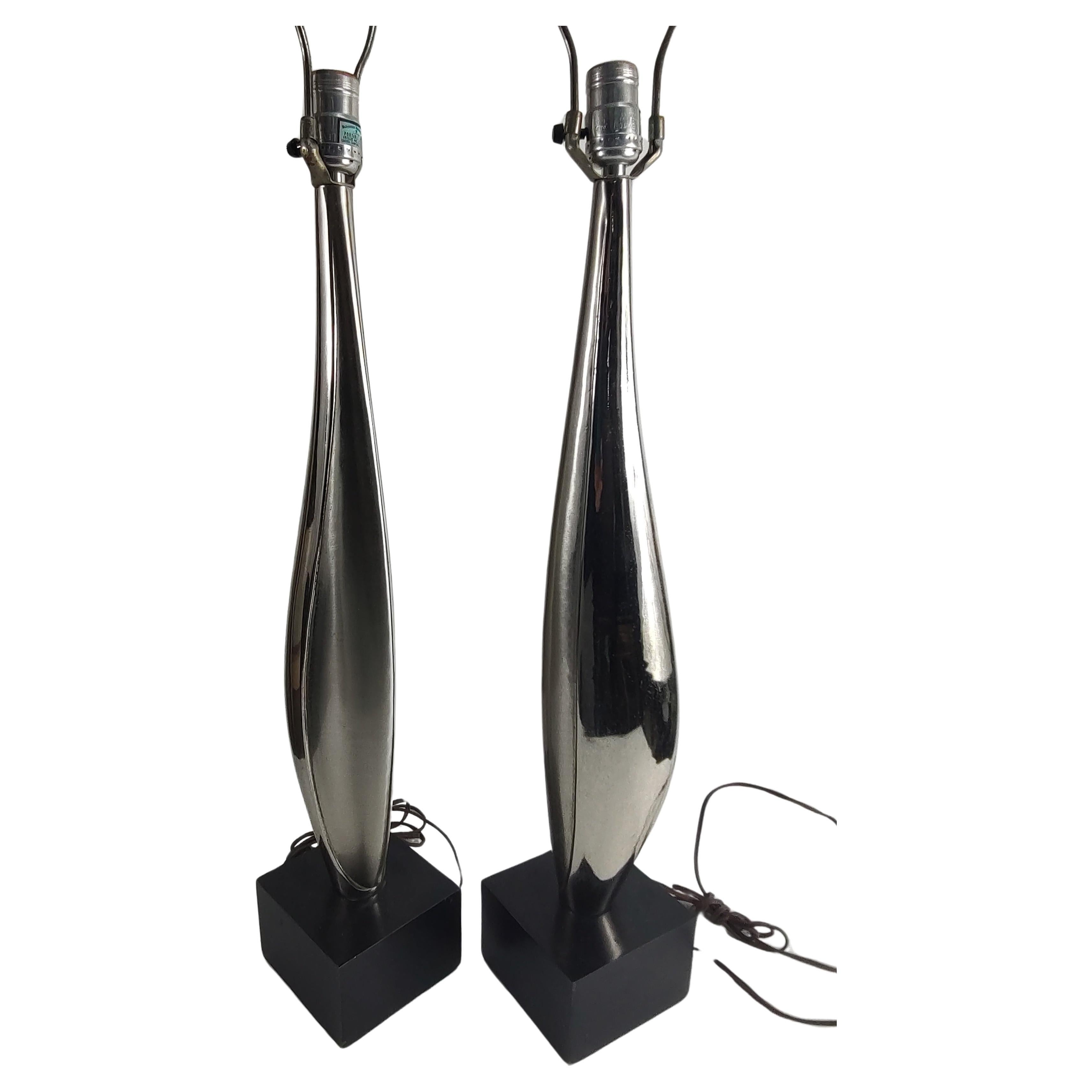 Simple and elegant pair of tall slender and sleek with a lot of sexy style. Chromed abstract figural central figures sitting on black plinths. 5 x 5 x 39h to the top of the finial. In excellent vintage condition with minimal wear, age related.