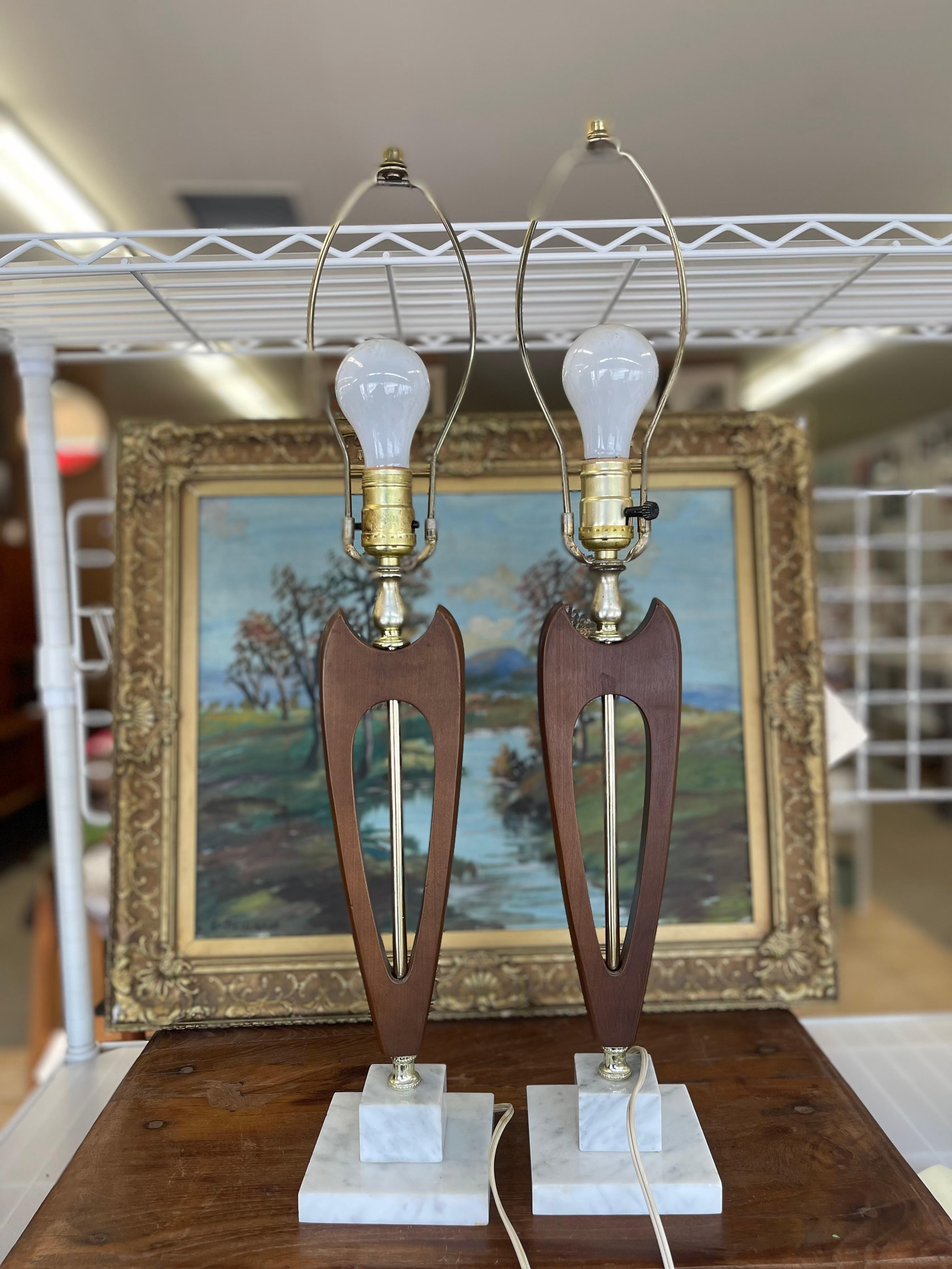  Cette paire de lampes de table modernes du milieu du siècle illustre l'accent mis par cette époque sur les lignes épurées, les formes sculpturales et le contraste des matériaux. Chaque lampe présente un corps en noyer sculpté en forme de goutte