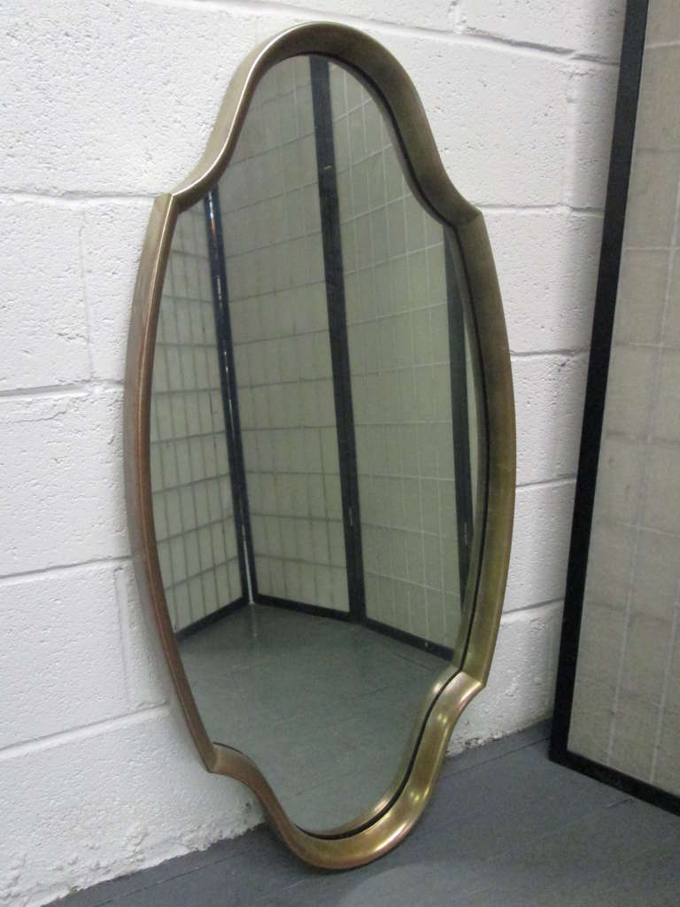Pair of Mid-Century Modern sculptural mirrors with gilded frame.