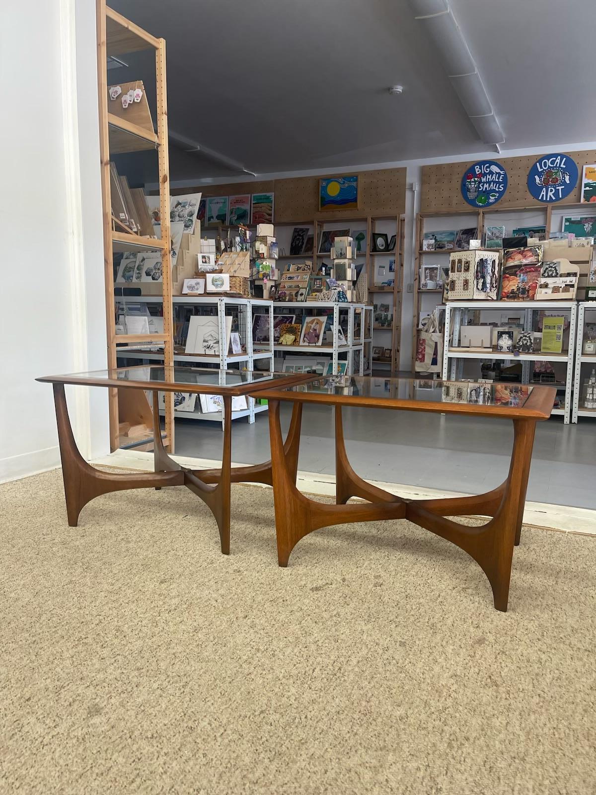 This pair of Mid-Century Modern end tables was crafted by Lane Furniture in the 1960s and is identified by style number 1163-05 and serial number 4175260. The design features a dramatic sculptural likely walnut base with intersecting arches that