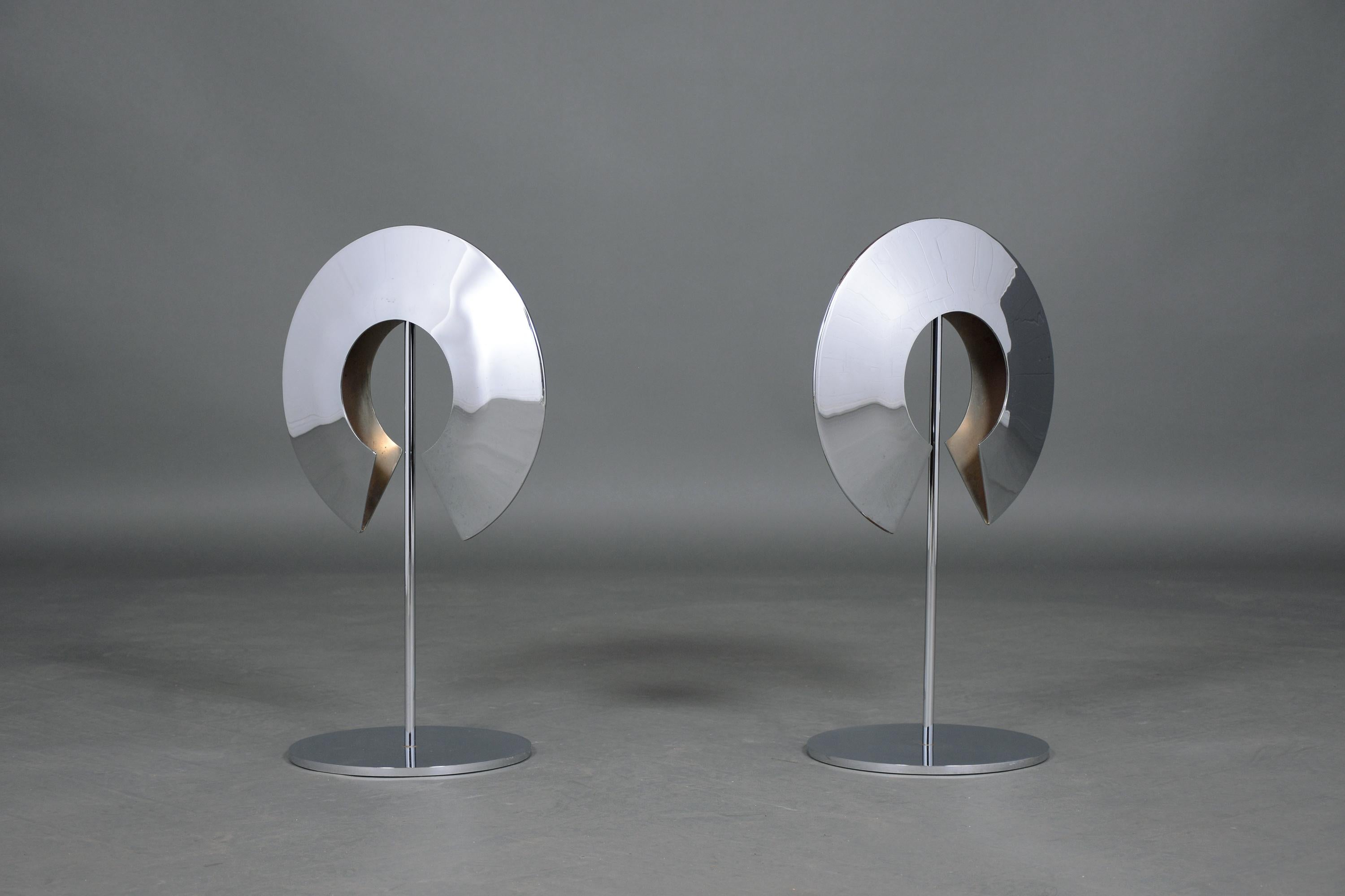 An extraordinary pair of modern sculptures crafted out of steel finished in chrome. These eye catching pieces are in good condition and they feature a crescent design supported by a circular base.