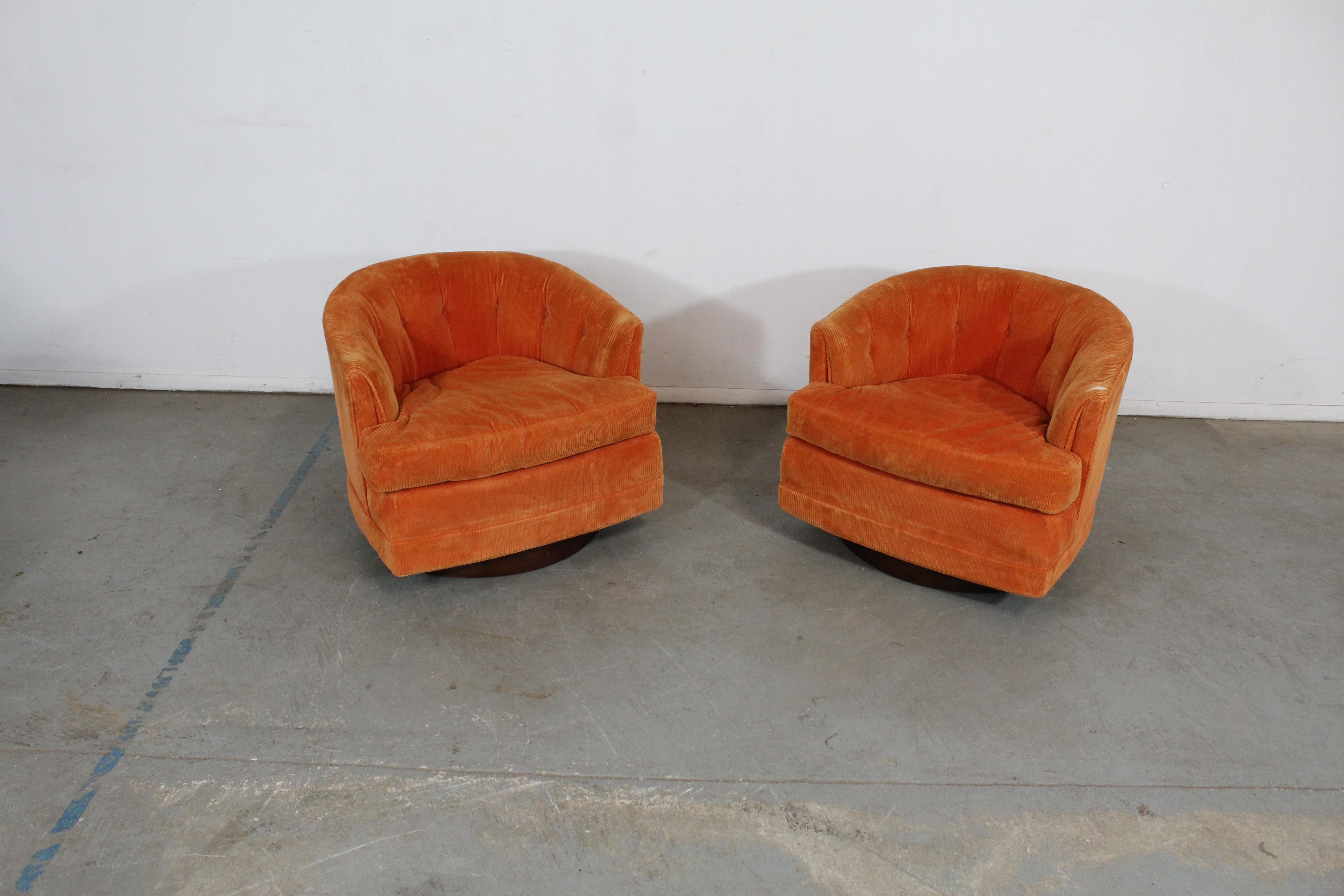 Pair of Mid-Century Modern Barrel back swivel club chairs

Offered is a pair of vintage Mid-Century Modern style swivel chairs by Selig. These chairs have round backs and walnut bases. They are in good condition, but need to be reupholstered with