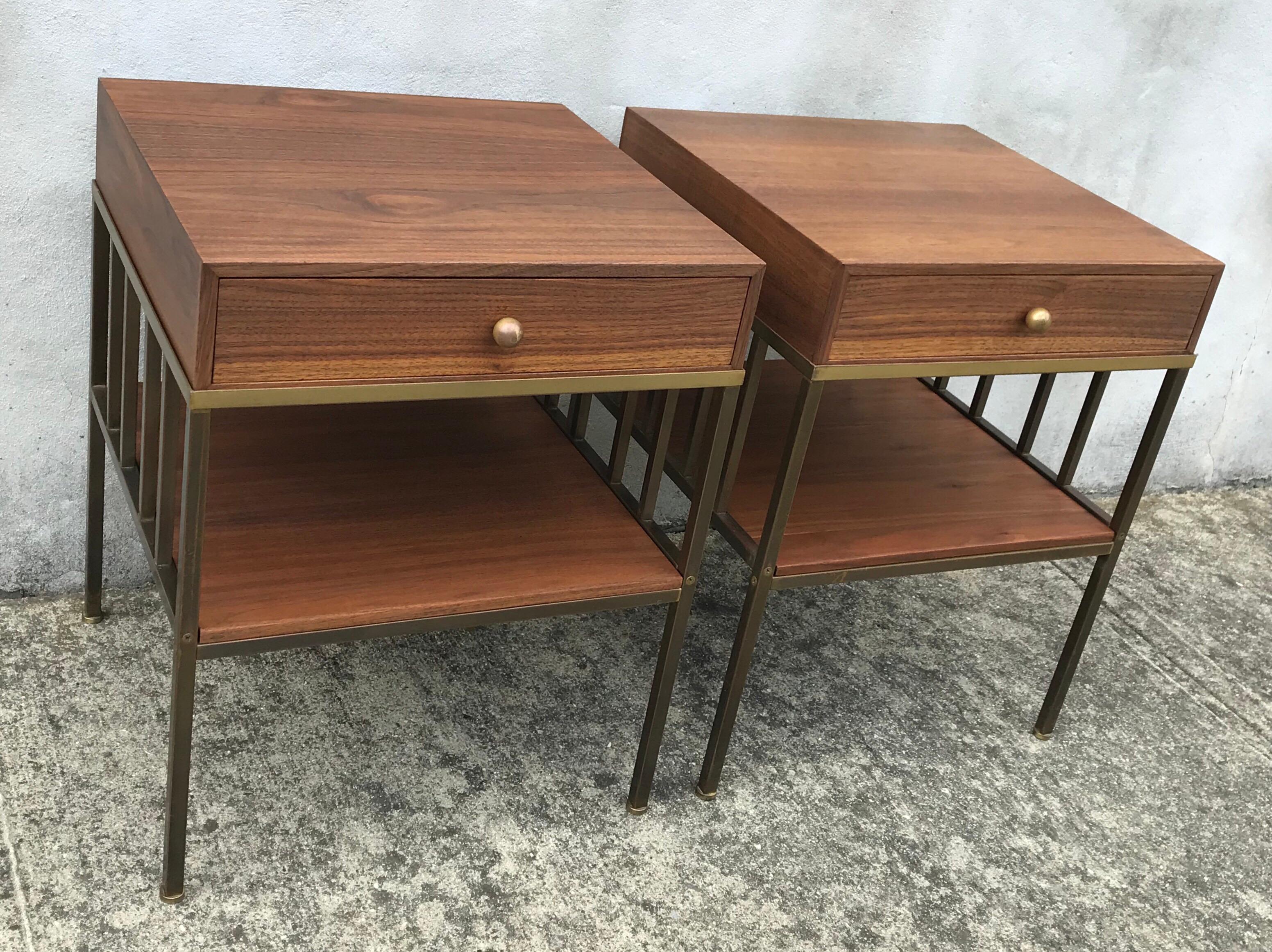 Amazing pair of nightstands or side tables by Paul McCobb for Directional, rare very early production. Solid walnut cubes rest in beautiful patina brass frames. Professionally restored.
