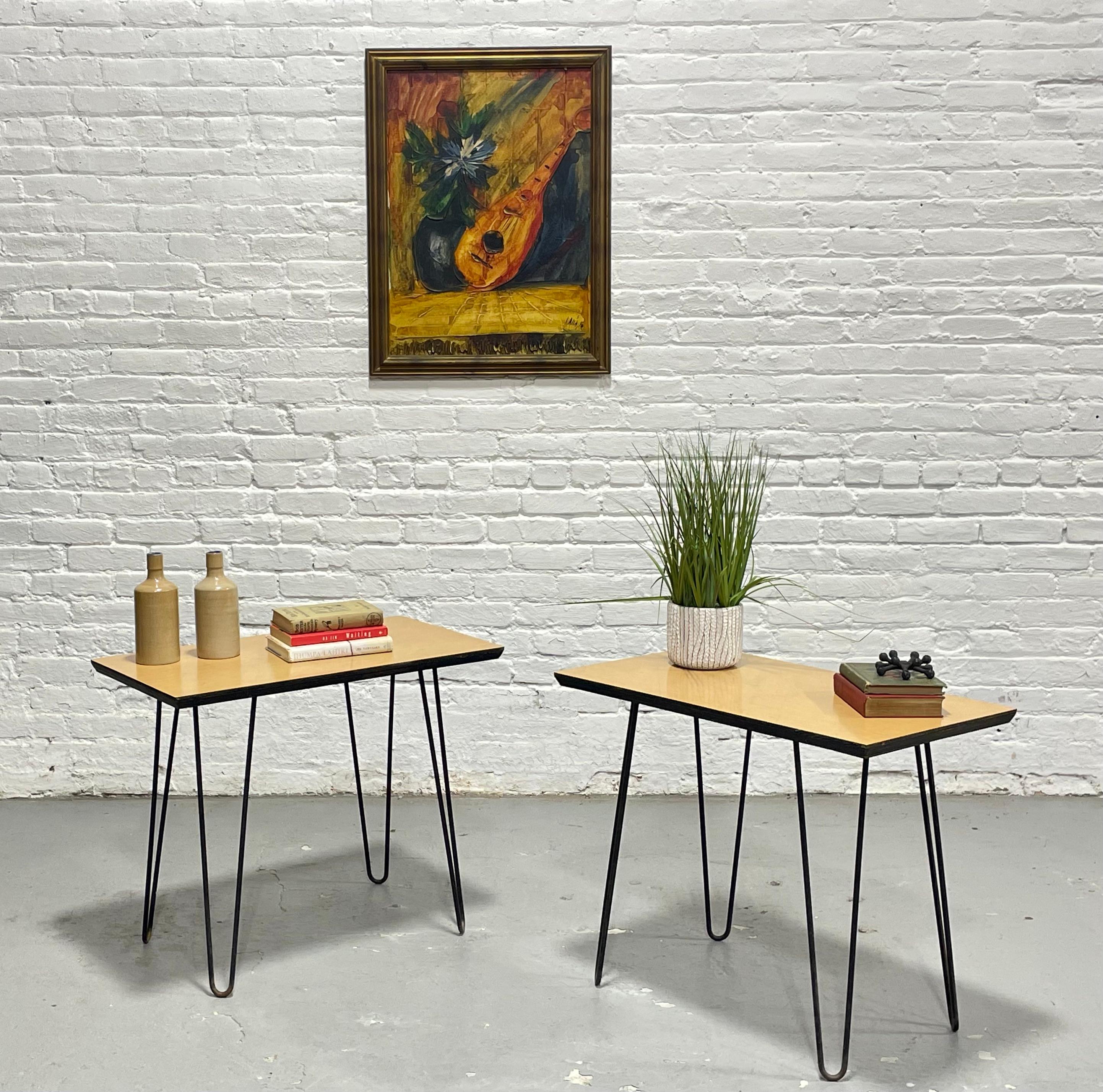 Este elegante par de mesas auxiliares modernas de mediados de siglo ofrece una sorprendente mezcla de diseño minimalista y durabilidad funcional. Cada mesa tiene unas patas de horquilla metálicas, altas y esculturales, que sostienen un tablero de