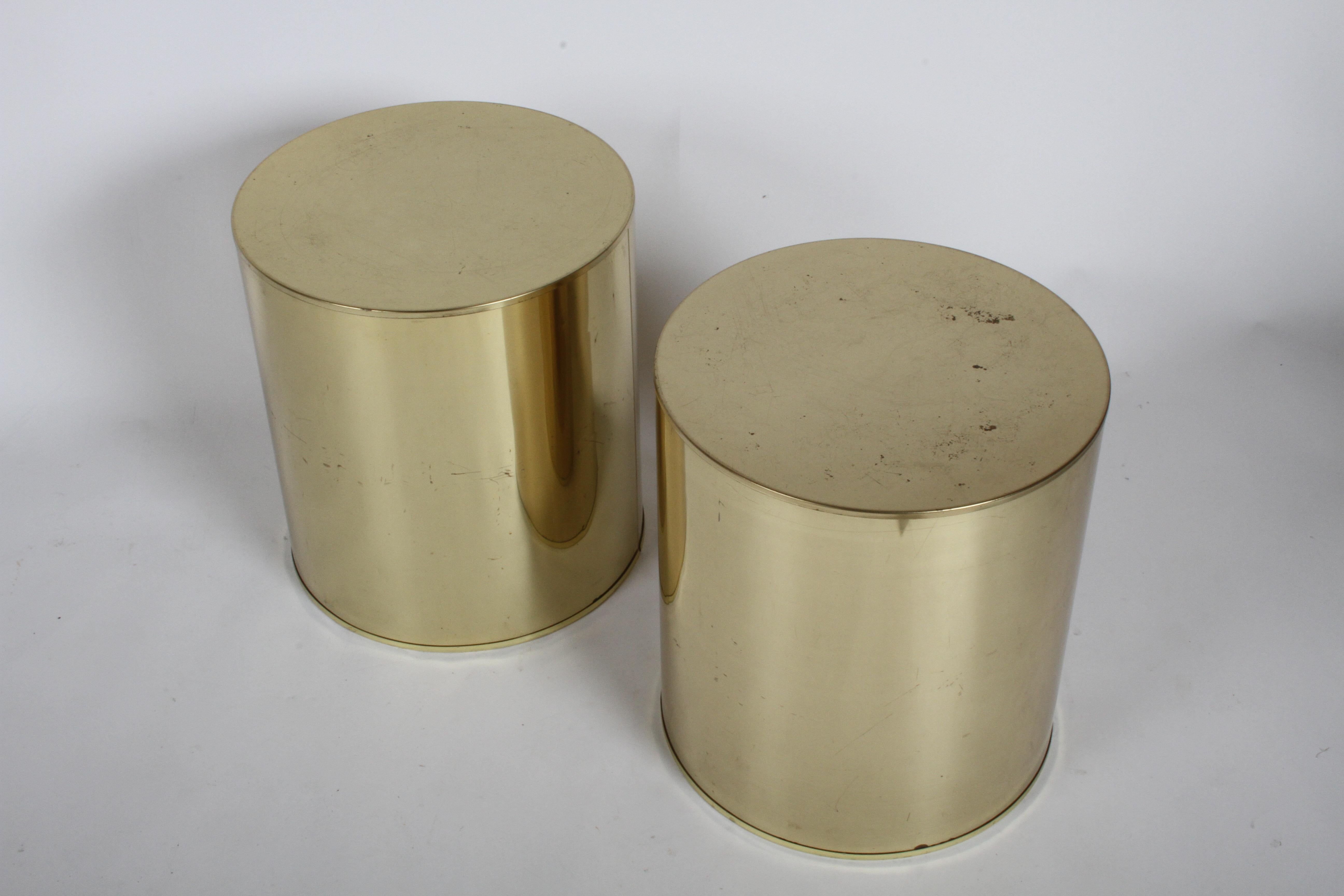 Pair of Hollywood Regency Curtis Jeré brass drum form end, side tables or display pedestals. Signed C. Jere, circa 1970s. Wear to finish on tops, some patina on sides, minor dings, metal is reflective so it picked up at lot flaws in the paper and