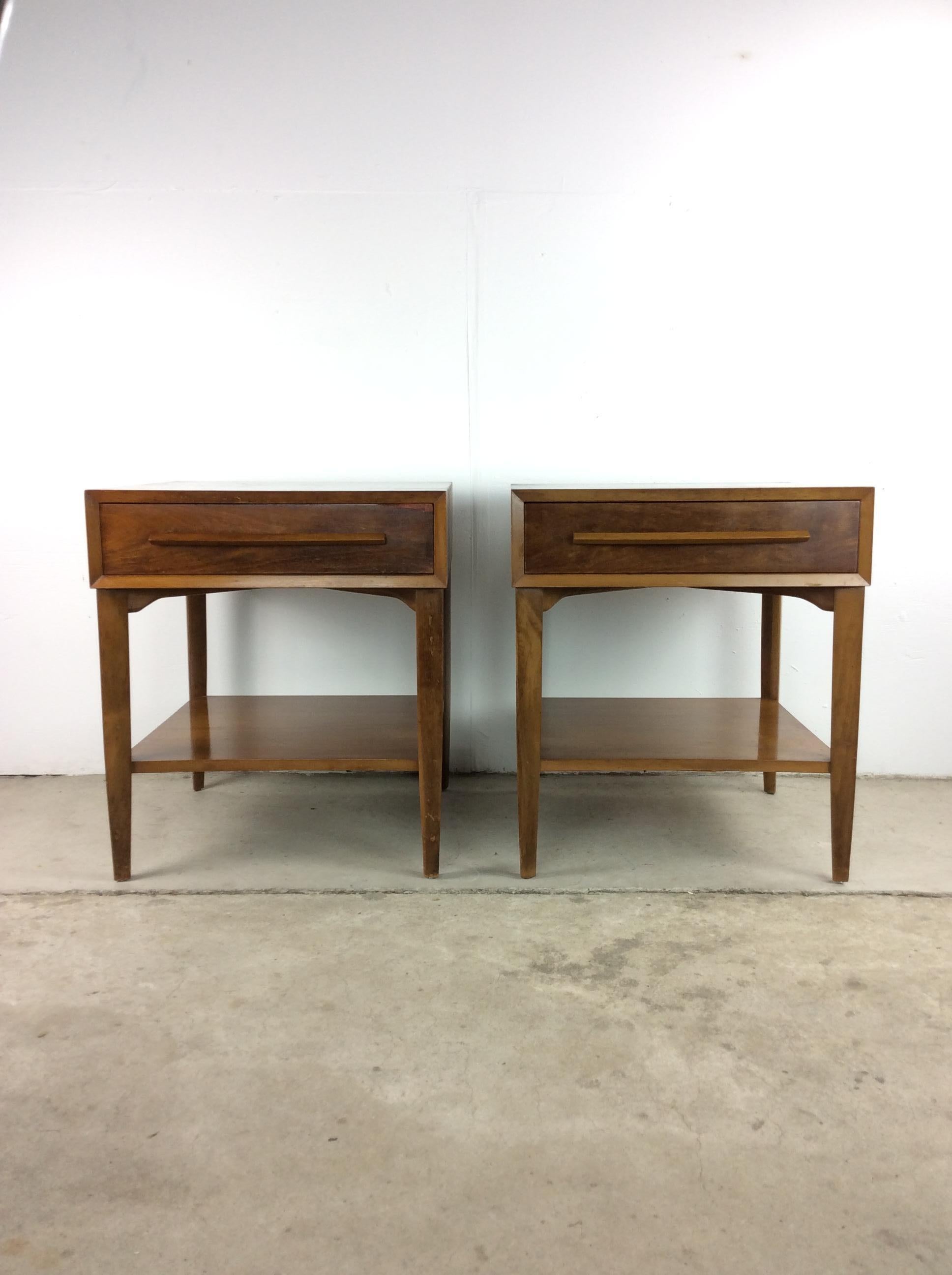 This pair of mid century modern nightstands by Widdicomb feature hardwood construction, walnut veneer with original finish, single dovetailed drawer, sculpted wood handle, lower storage shelf, finished back, and tall tapered legs.

Matching lowboy