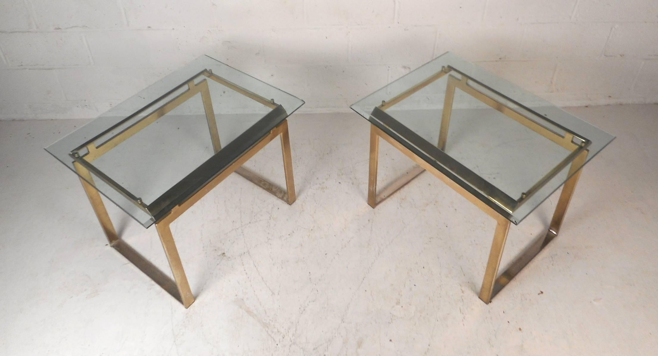A stunning pair of vintage modern end tables with floating style glass tops with bevelled edges. Heavy metal bases and thick glass tops with a light tint of green adds to the midcentury appeal. A stylish design that looks amazing in any home,