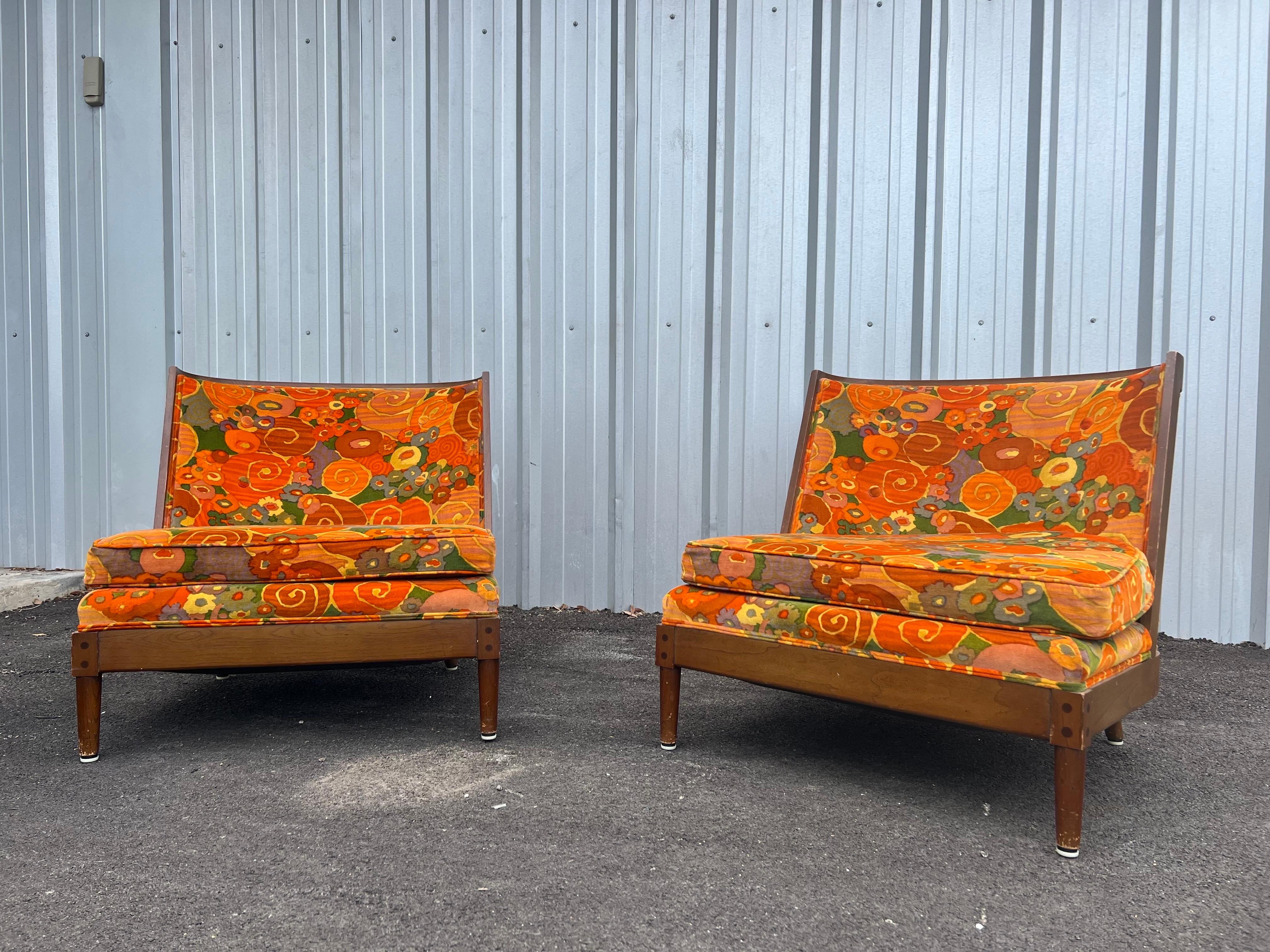 Pair of Mid-Century Modern slipper chairs made of fruitwood with original Jack Lenor Larsen fabric who is known for his bold use of colors and patterns. This pair of vintage lounge chairs are in good overall condition. There is some wear on the