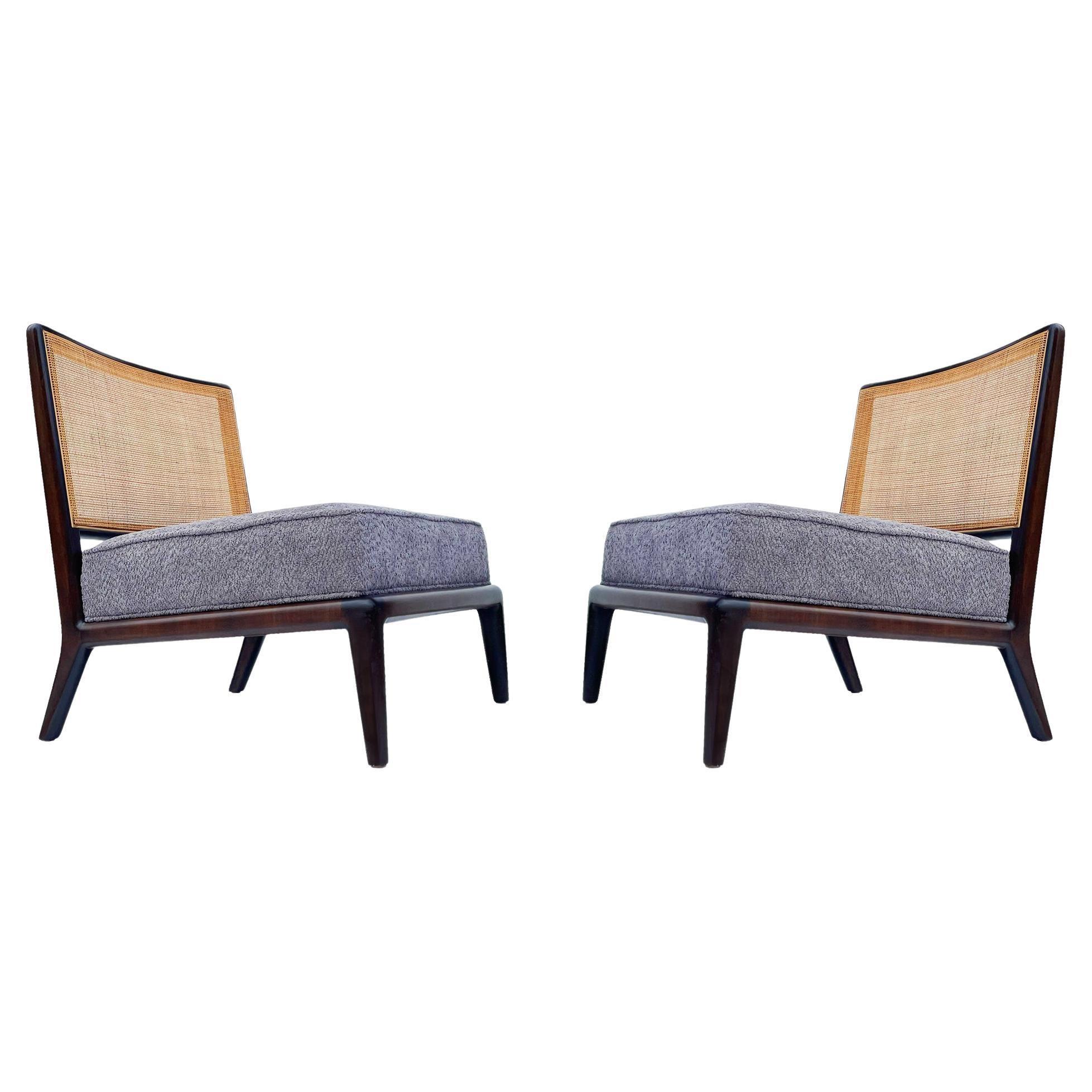 A sleek modern pair of slipper chairs attributed to Robsjohn Gibbings. These feature dark stained solid wood frames. The caning and grey boucle upholstery were recently done. Clean ready to use chairs. 