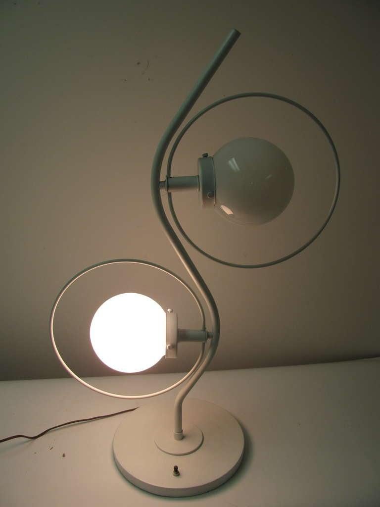Fabulous Pair of 1960s white lacquered lamps. Tall, sculptural lamps with a three way switch that powers opaque globes. Brass frames. This item can be parcel posted.