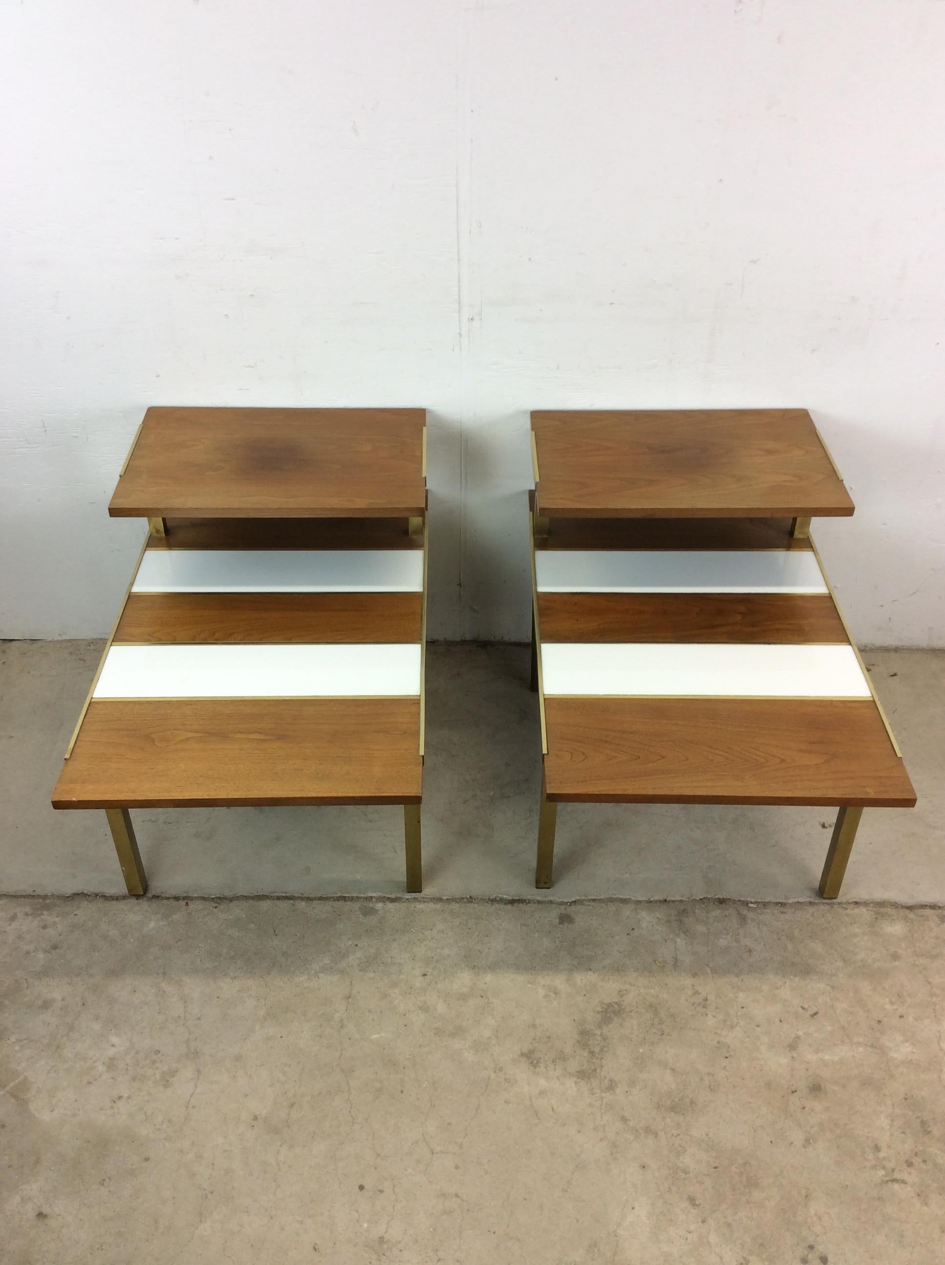 Questa coppia di tavolini da salotto della metà del secolo scorso è caratterizzata da una struttura in legno duro, intarsi in lacca bianca, design a due livelli e gambe in ottone. u2028u2028Il tavolino abbinato è disponibile
