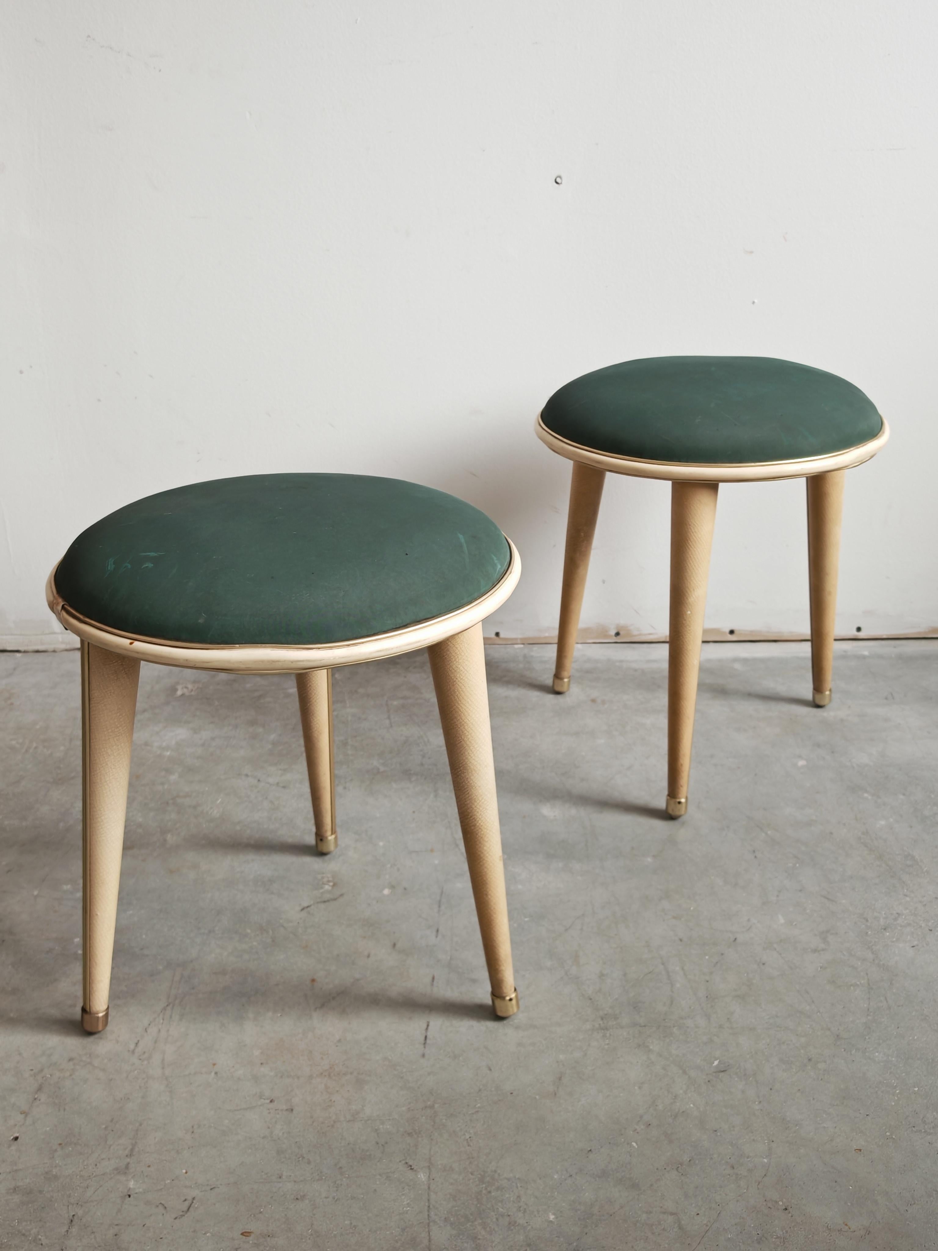 In diesem Angebot finden Sie ein Paar Mid Century Modern Hocker, entworfen von Umberto Mascagni. Sie sind mit einem Holzrahmen, weißer Kunstlederpolsterung, Messingfüßen und grünem Bezugsstoff ausgestattet. Die Sitze sind rund und mit einem