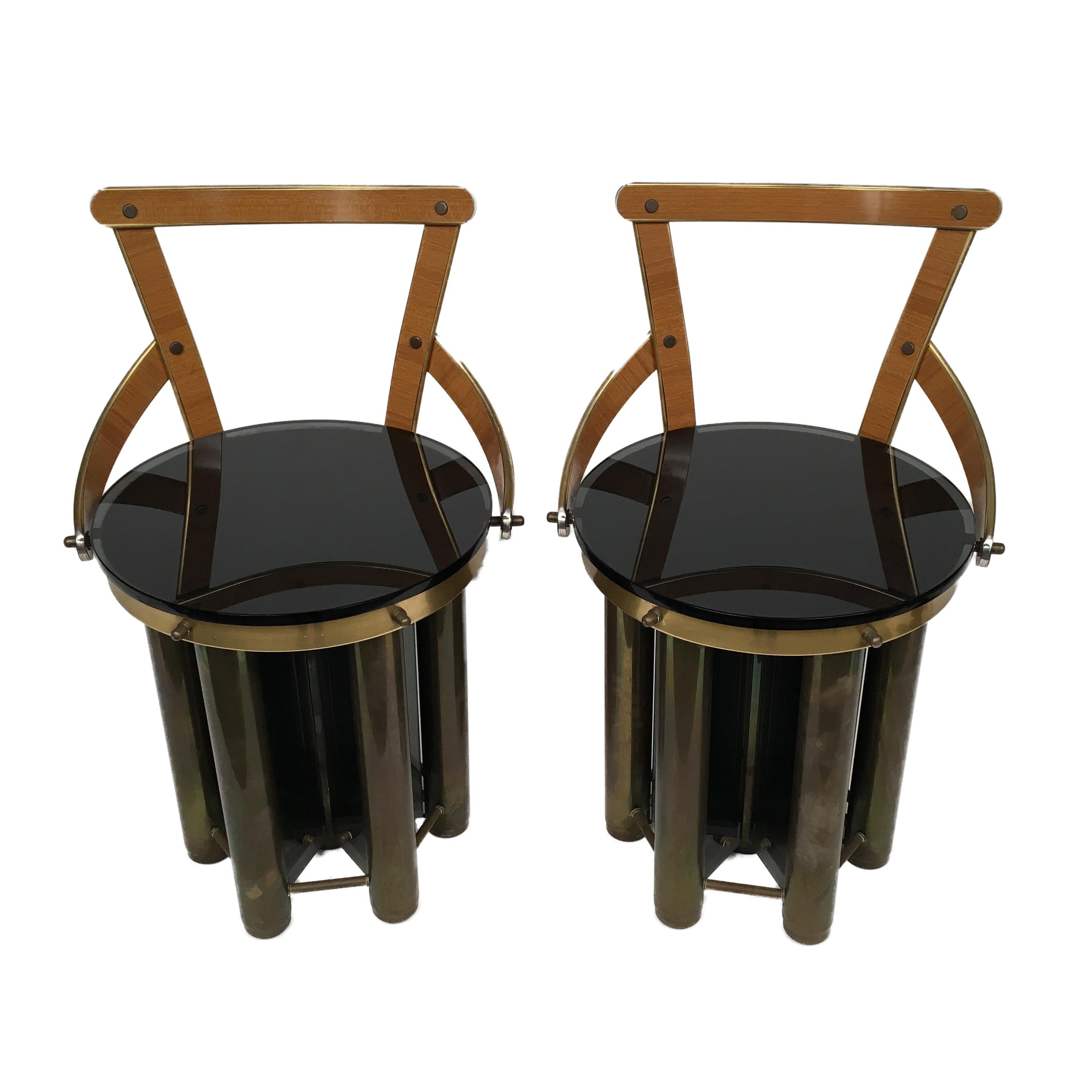 These two incredible stools are one of a kind, supported by heavy brass tubes linked together by dark glass, with small wheels on his bottom.
They have backrests processed in steel and covered with Formica. The cow seat cover can be removed, such