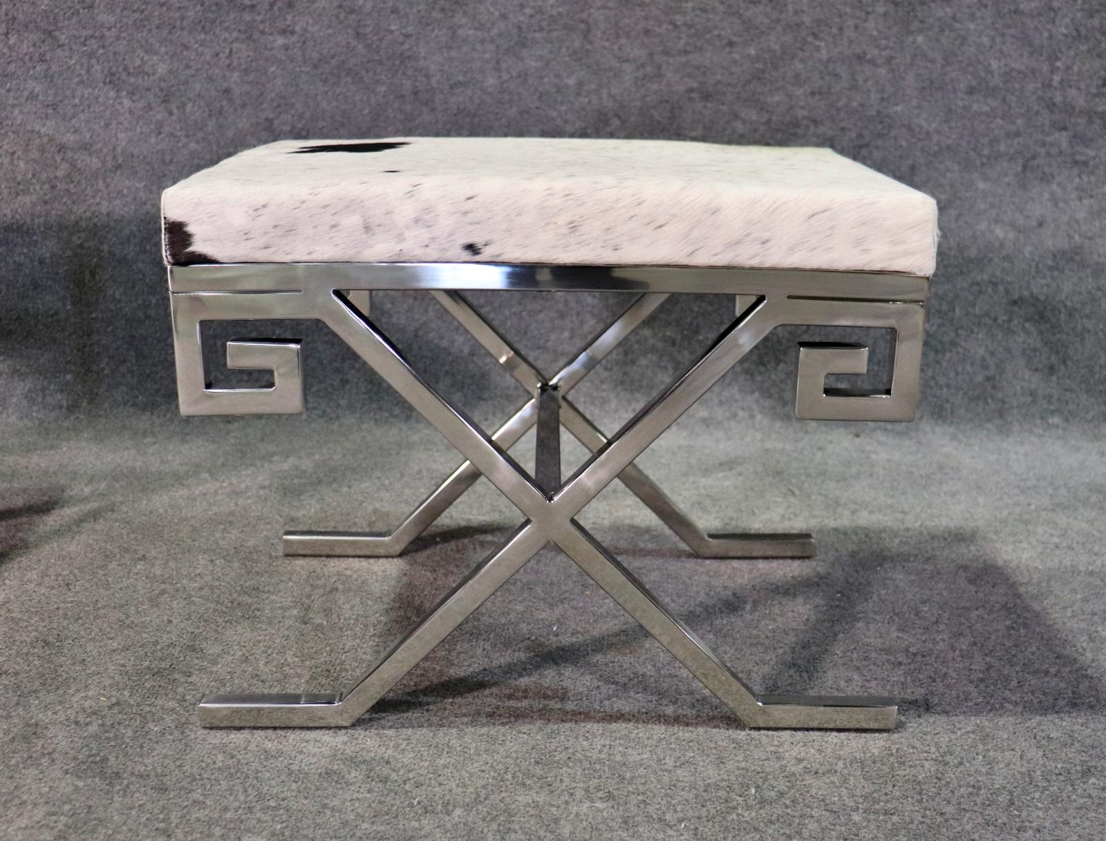 This is a beautiful pair of Jean Michel Frank style chromed steel and cowhide stools are in good condition with minimal if any signs of use and clean neoclassical Greek Key style and juxaposed with genuine natural cowhide creates a wonderful aura.