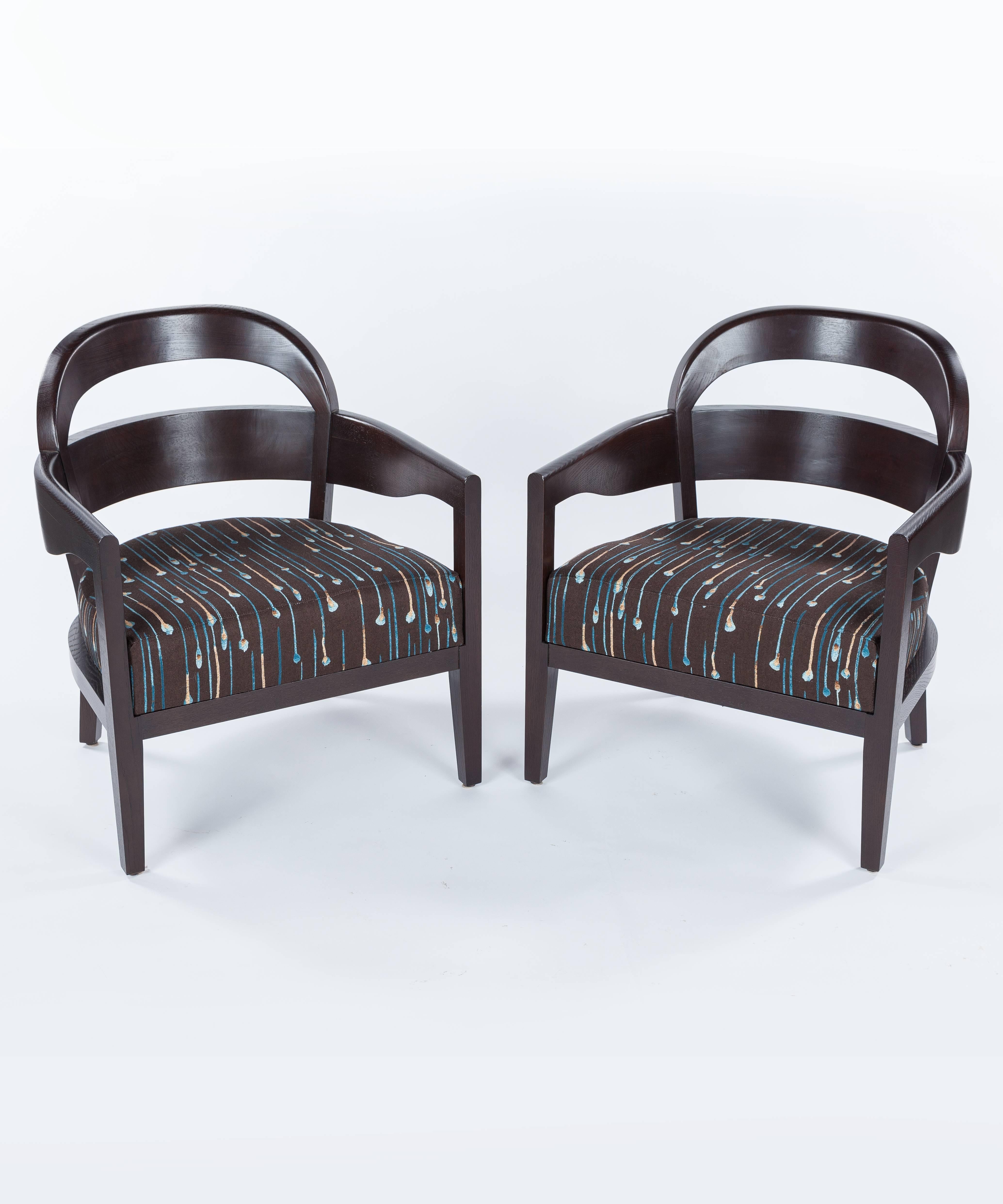 A pair of Mid-Century Modern in the style of Jiun Ho Mopane lounge chairs dating to the late 20th century. Featuring Rift Sawn oak and re-upholstered in a Jim Thompson linen fabric. Each chair measures approximately 26