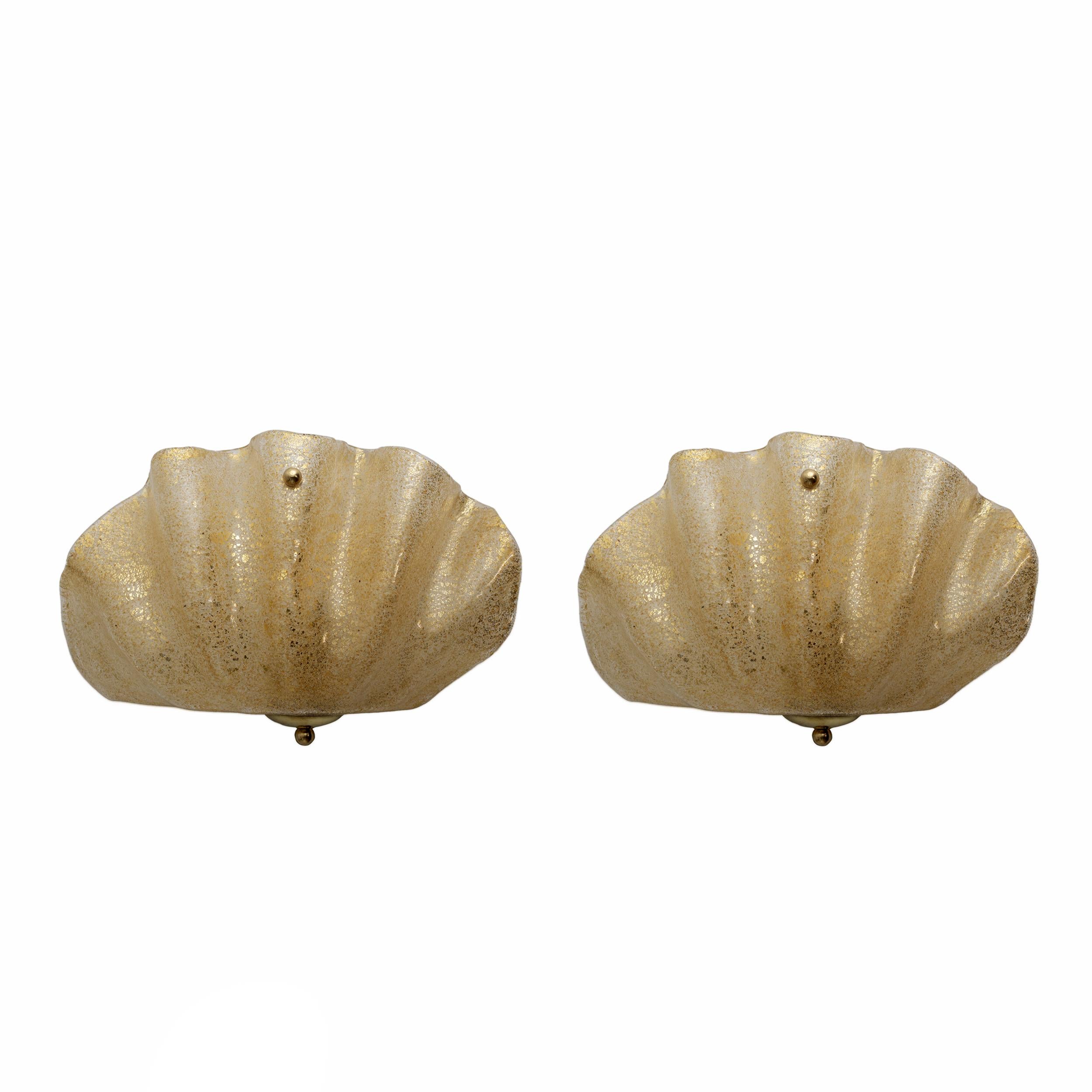 Coppia di lampade da parete in vetro di Murano a forma di conchiglia. Graniglia in vetro di Murano, liscia all'esterno e ruvida all'interno, con polvere e foglia d'oro all'interno del vetro. Dotato di due portalampada G9 e ricablato per gli standard