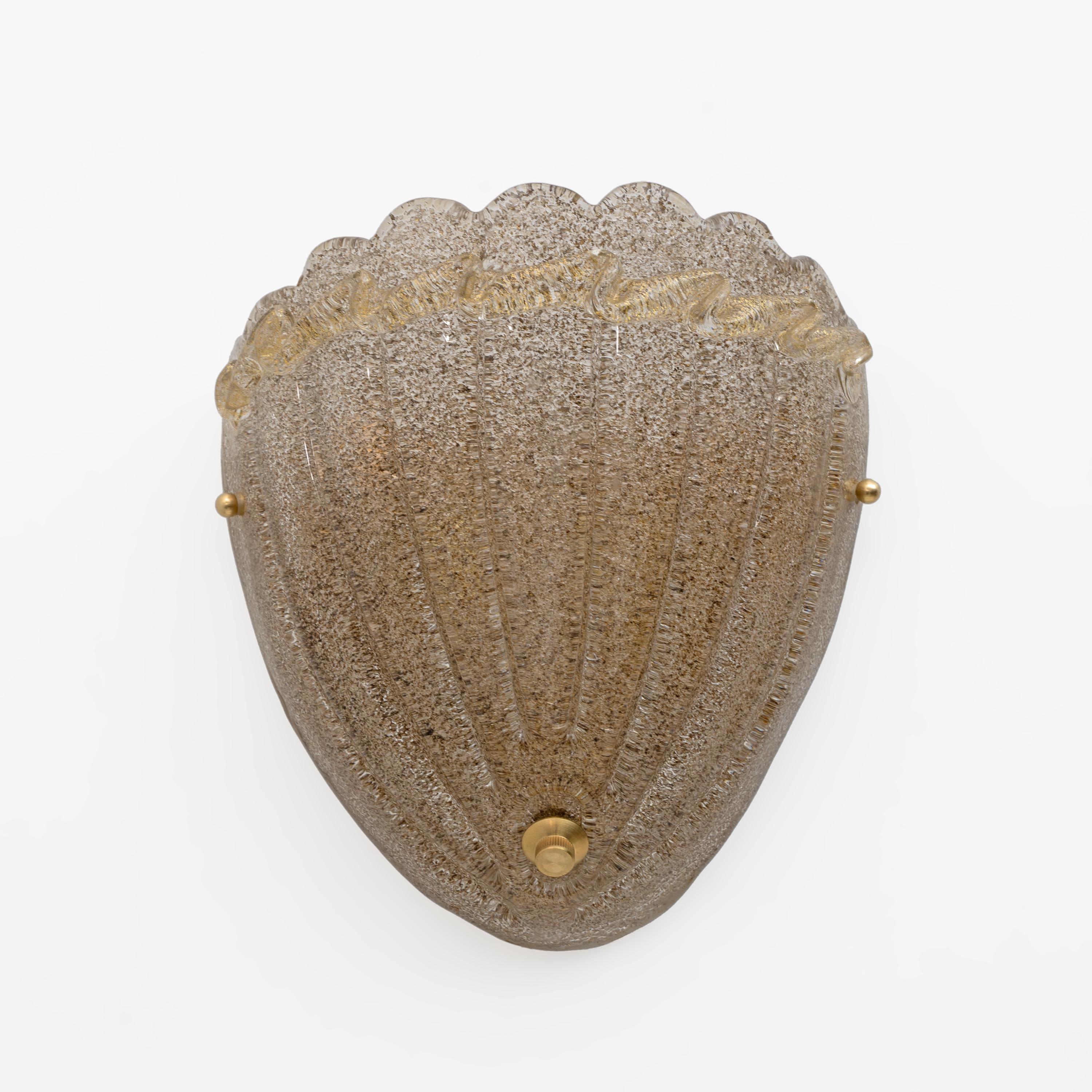 Two Art Deco wall lamps in the shape of a shell. Made of Murano Graniglia glass, mounted on a brass base. The wall lamps have two lights each and are equipped with an E14 socket for Europe or E12 for the United States.