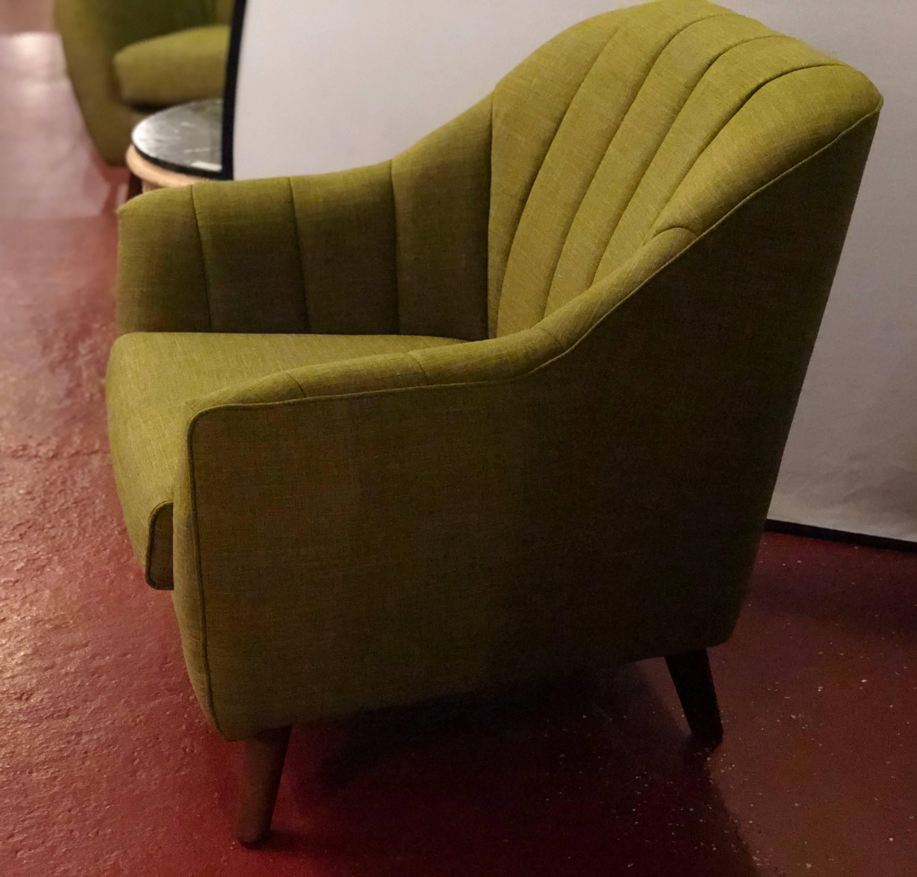 Pair of Mid-Century Modern style oversized chairs. Having a line tufted backrest this pair of very comfortable arm or lounge chairs would look wonderful in any setting. Each having a new olive green upholstery.
