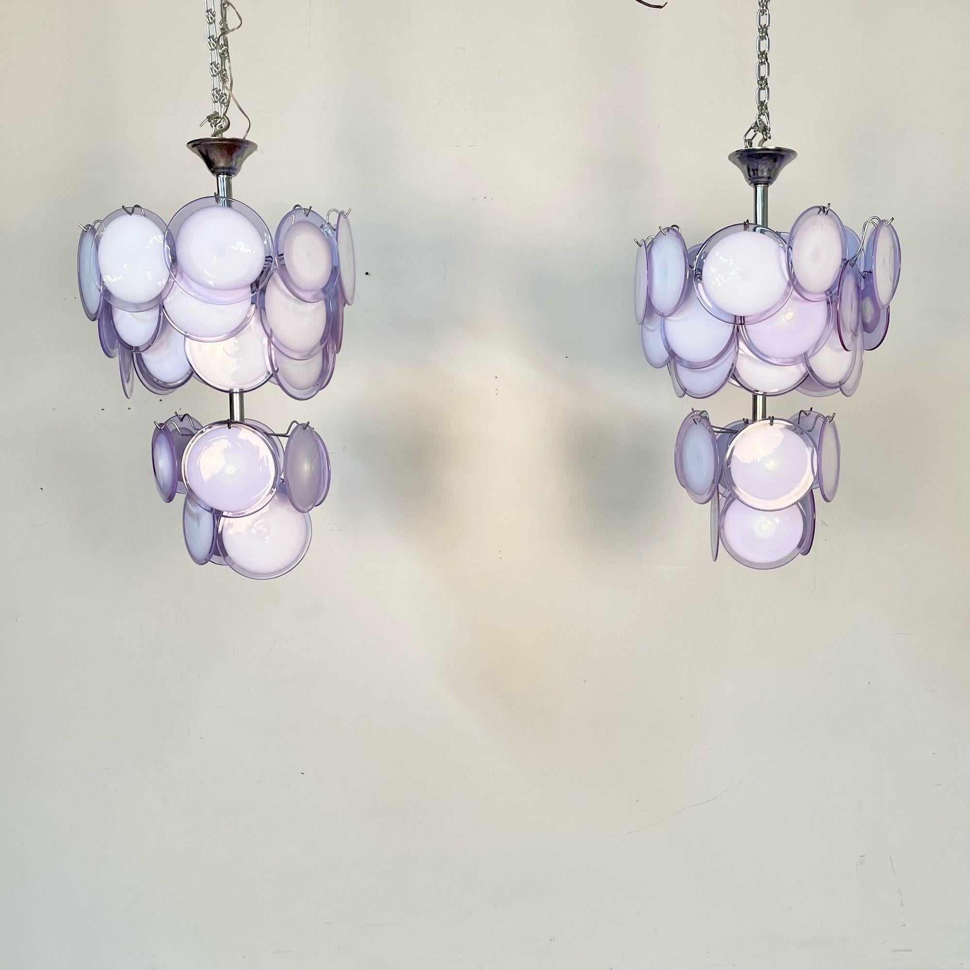Pair of Mid-Century Modern Style Purple Murano Glass Disk Chandeliers
A pair of mid-century modern Murano glass chandeliers in a classic suspended disks configuration. Each fixture has 18 translucent purple over white Murano glass disks mounted on a