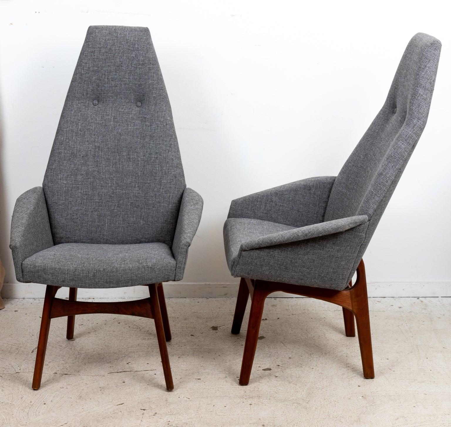 Circa mid-20th century pair of high back chairs in the Mid-Century Modern style by Wilkes-Barre, PA based designer Adrian Pearsall. The chairs feature high seat backs with tufted buttons and turned Walnut legs. Made in the United States. Please note