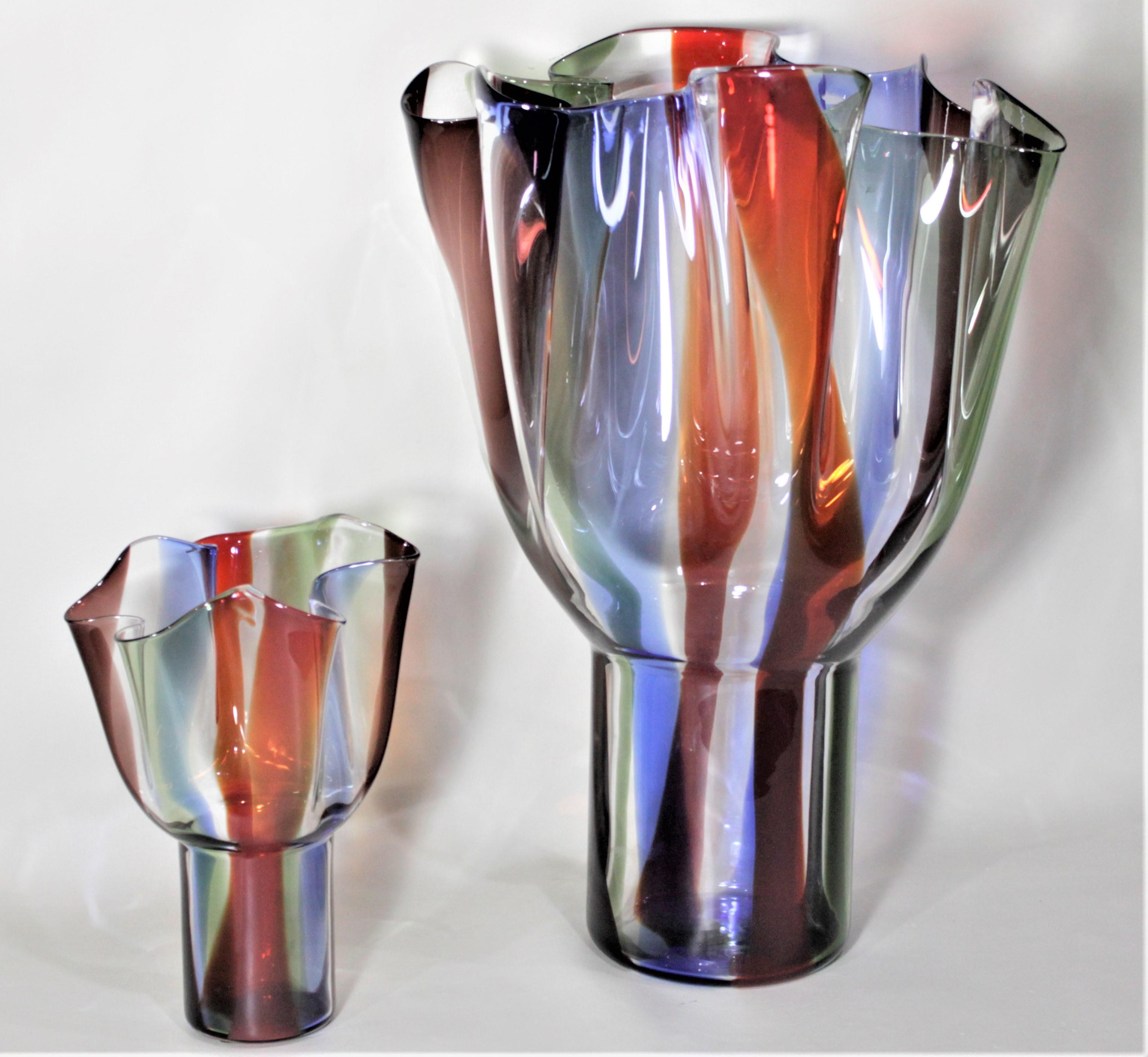 This pair of art glass Kukinto vases were designed by Timo Sarpeneva for Venini. The set is composed of one extremely large vase with multicolored bands or ribbons running down each side, and one done in the same style, but much smaller in size. The