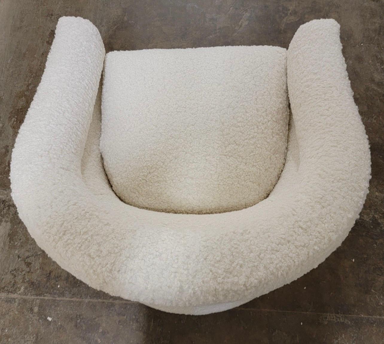 A stunning pair of curved form barrel back swivel chairs, circa 1970s by Jalen which was a small custom manufacturer. They have been newly reupholstered in a boucle faux shearling fabric which gives this set not only a luxurious look but a