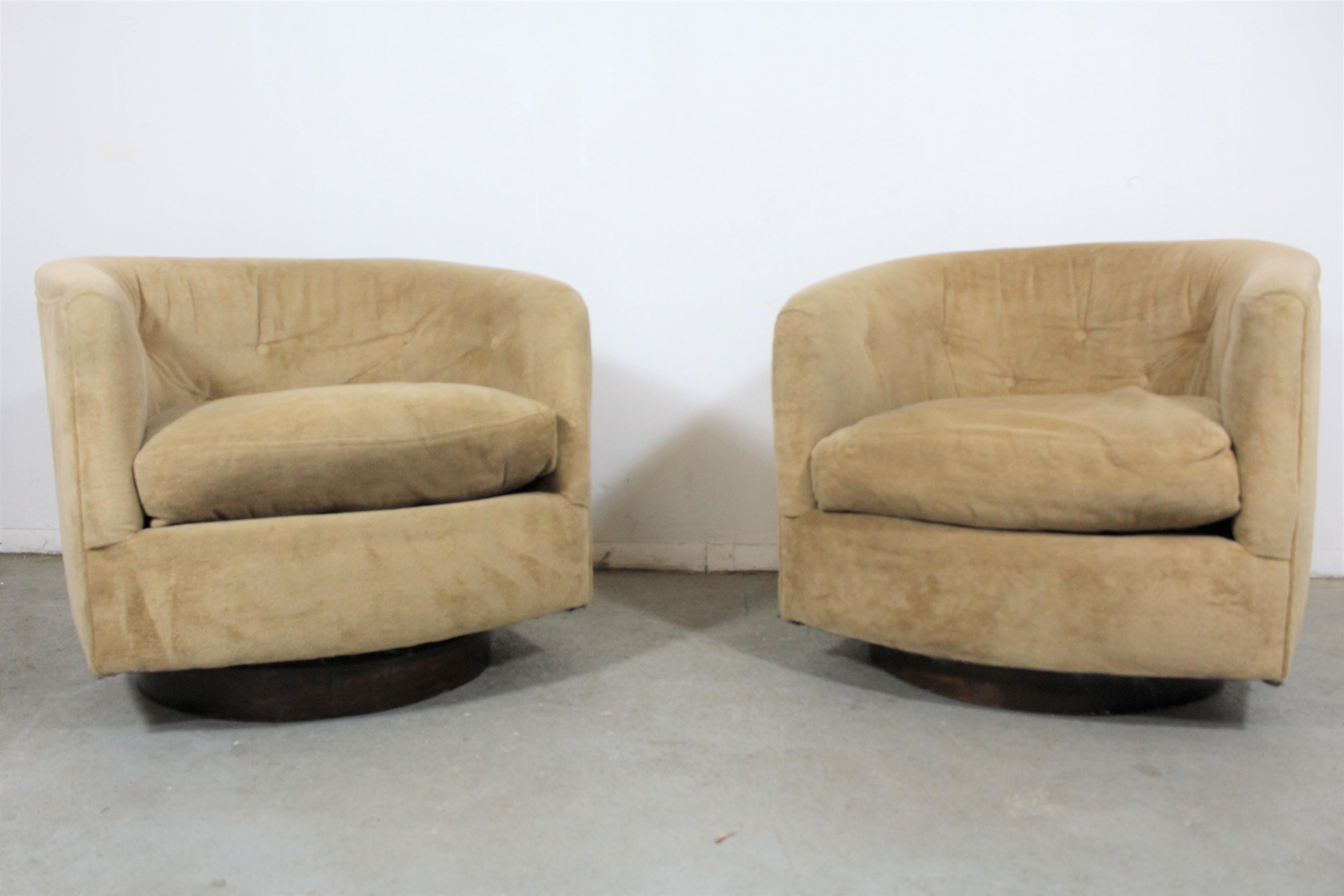 Pair of Mid-Century Modern swivel club chairs 

What a find. Offered is a pair of swivel chairs on walnut bases. The upholstery is in usable condition and it is structurally sound. The walnut base has some surface scratches and age wear. They are