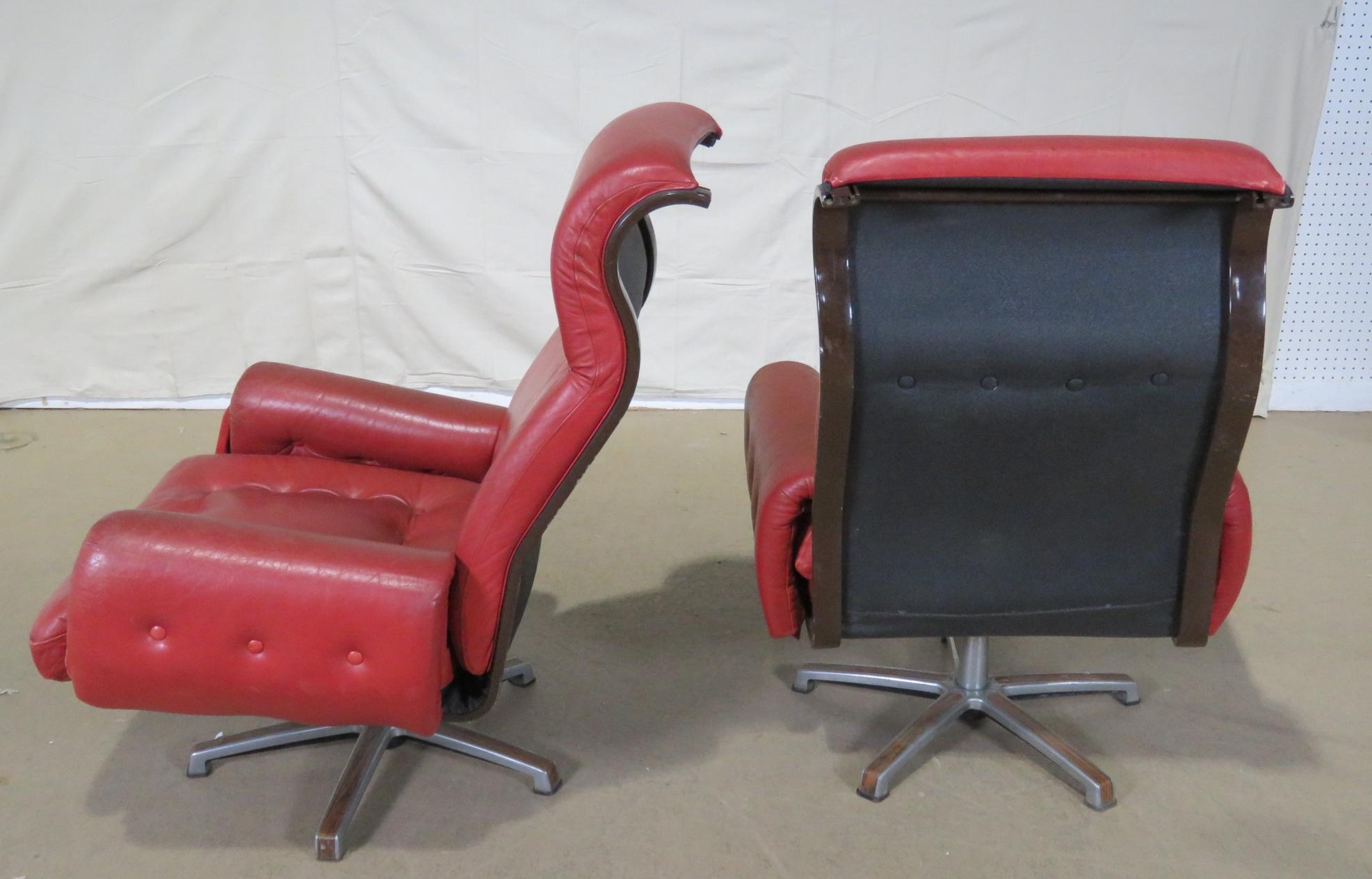 Pair of Mid-Century Modern swivelling distressed leather lounge chairs on chrome bases.