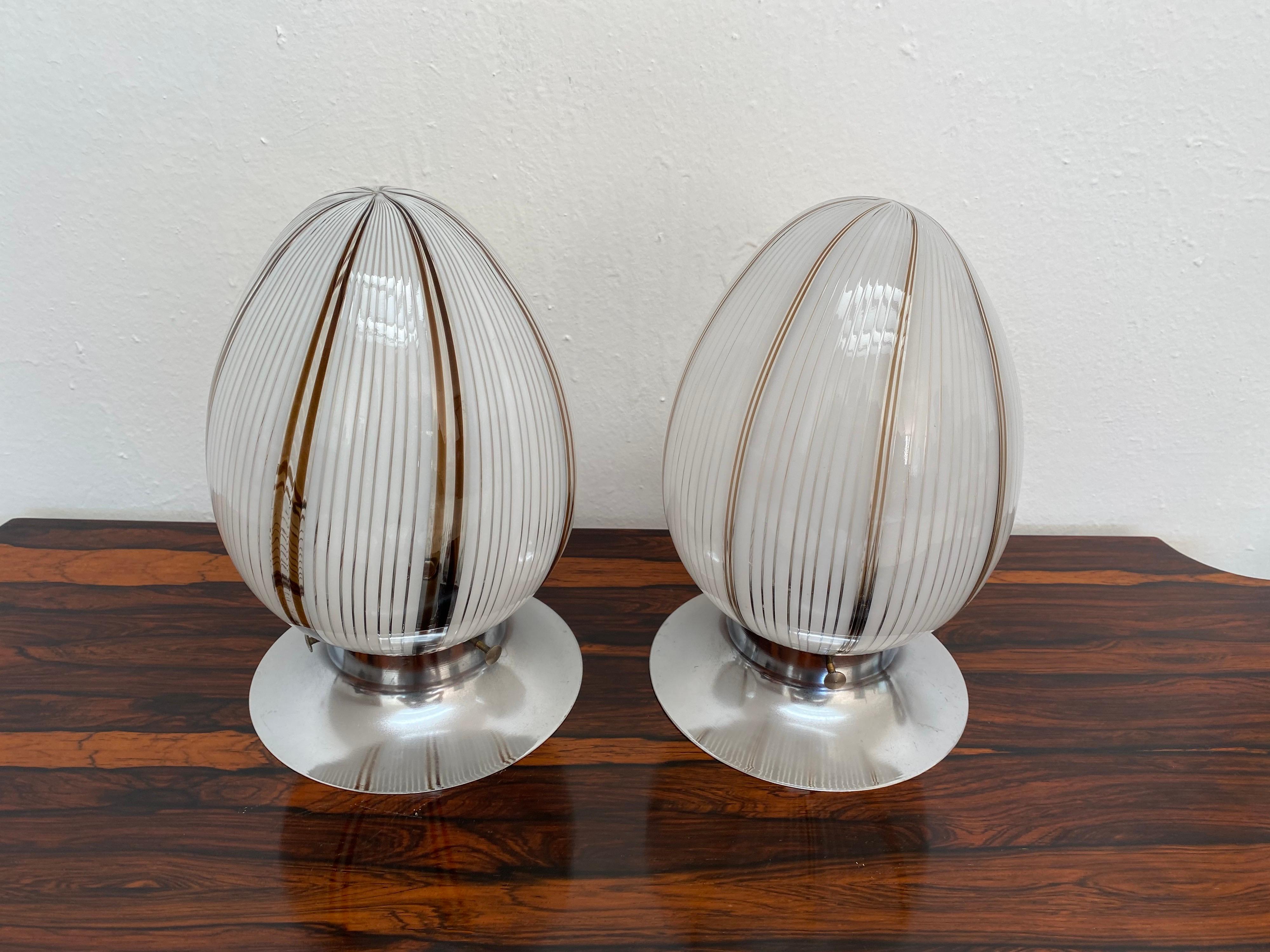 Pair of Space Age one-light, egg-shaped table lamps attributed to Venini, circa 1980.
Hand blown in white, clear and black Murano glass and chromed bases.
They each hold one E14 bulb.
