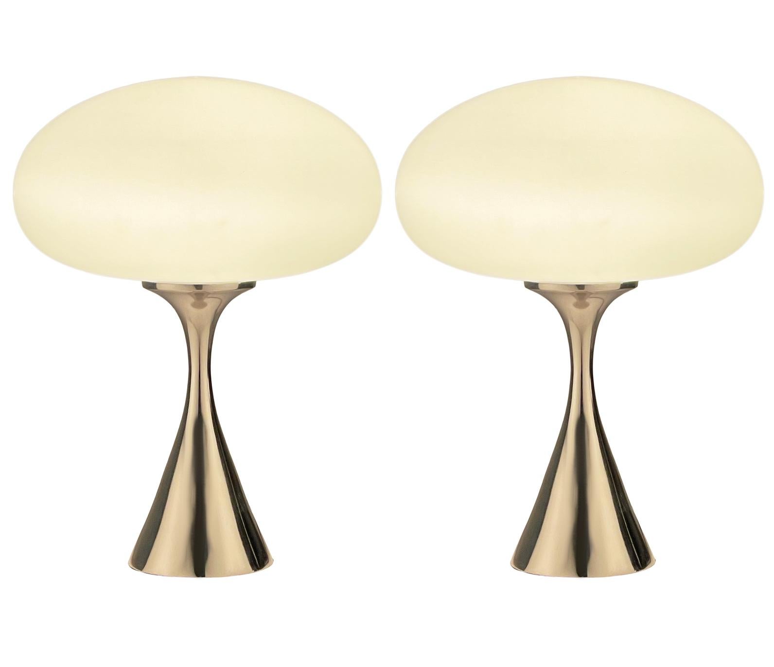 A handsome matching pair of table lamps in a conical mushroom form after Laurel Lamp Company. The lamps feature a chrome plated cast aluminum base with a mouth blown frosted glass lamp shade. Price includes the pair as shown.