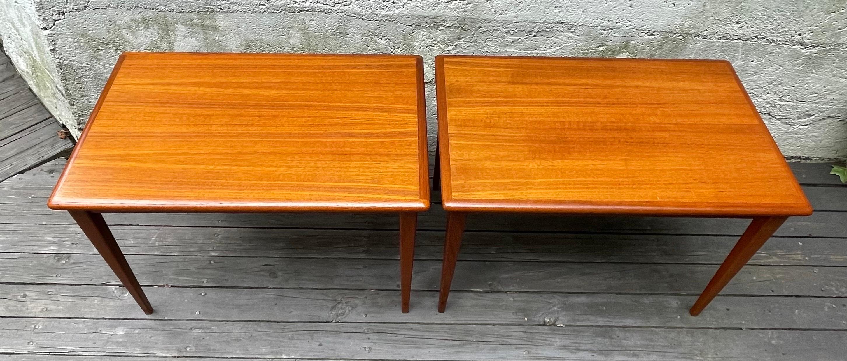 Beautiful pair of Mid-Century Modern teak side tables or end tables with sleek legs and nice finished edges. Made in Denmark, 1960's.