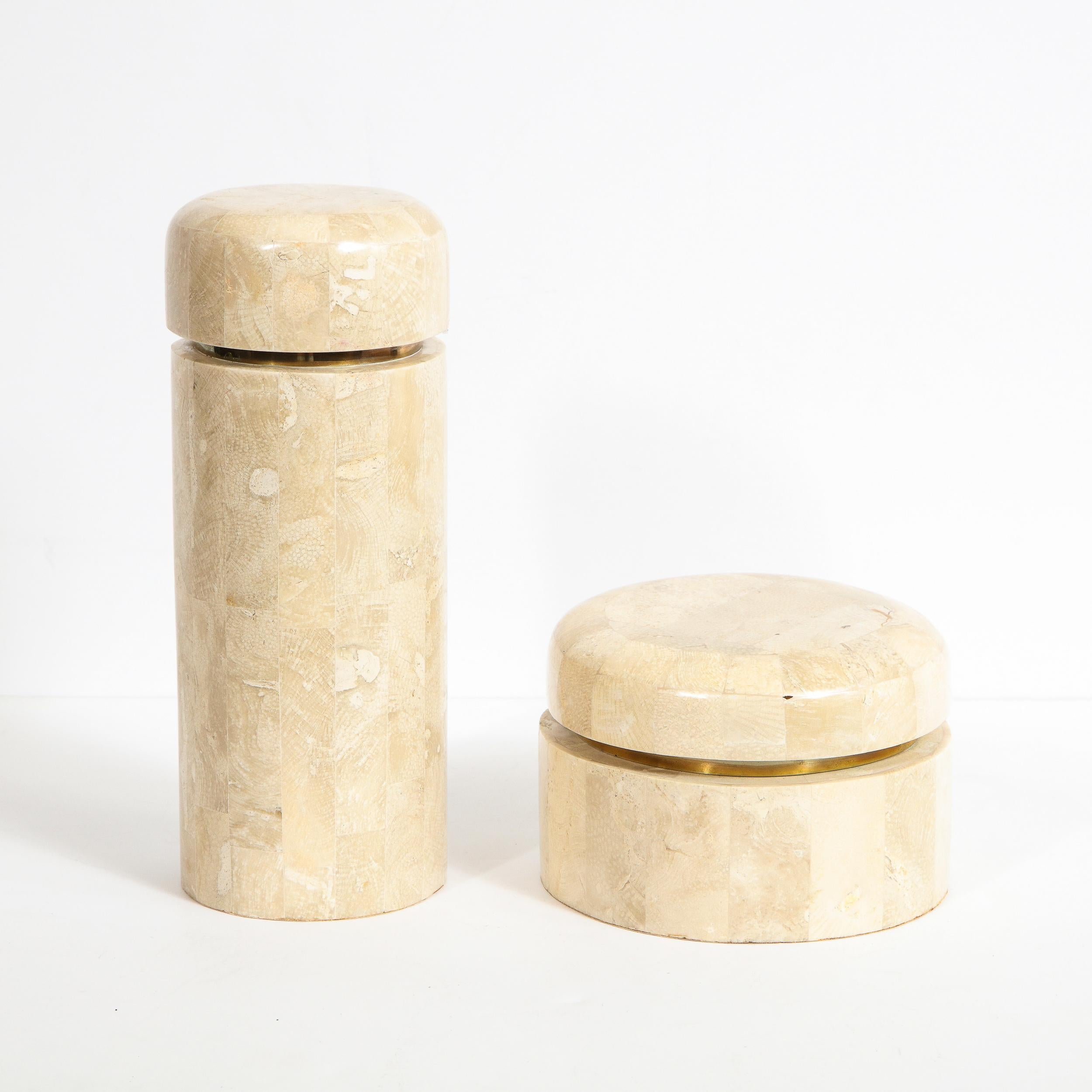 Cette élégante paire de boîtes modernistes a été réalisée par le célèbre cabinet de design du XXe siècle Maitland Smith aux Philippines, vers 1980. Elles présentent deux corps cylindriques - l'un plus court et plus grand en diamètre, l'autre plus